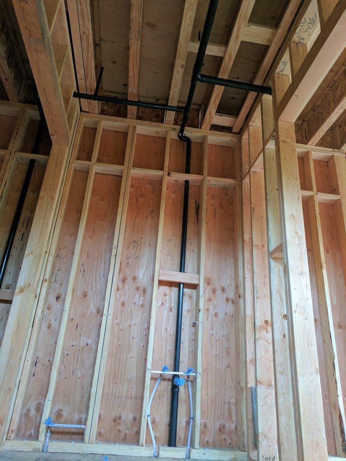 A pipe is hanging from the ceiling of a building under construction.