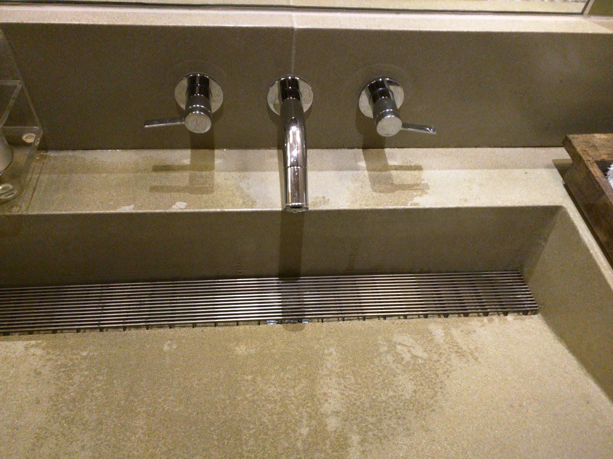 A bathroom sink with three faucets and a drain.