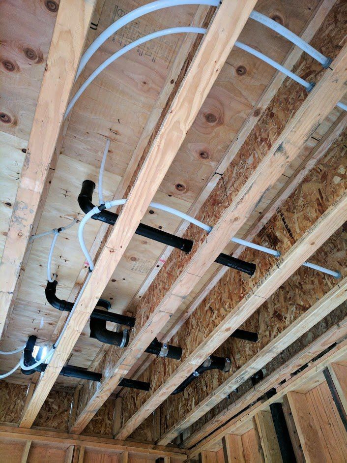 There are a lot of pipes hanging from the ceiling of a building.