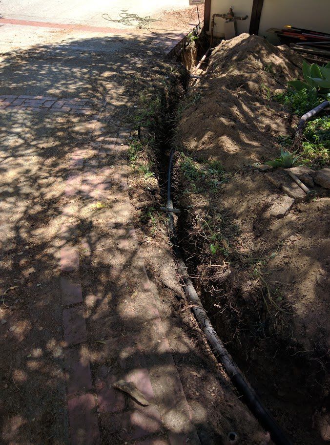 A hole in the ground with a hose coming out of it.