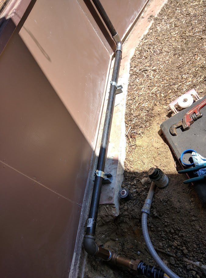 A pipe is being installed on the side of a building.