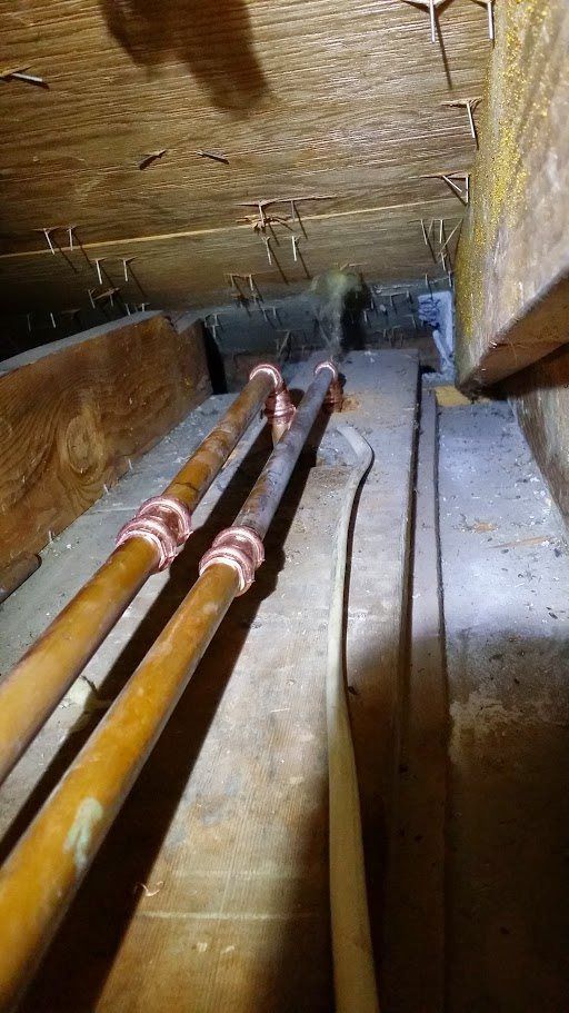 A bunch of pipes are hanging from the ceiling of a room.