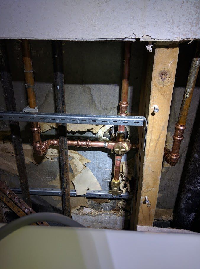 A bunch of pipes are hanging from the ceiling in a room.