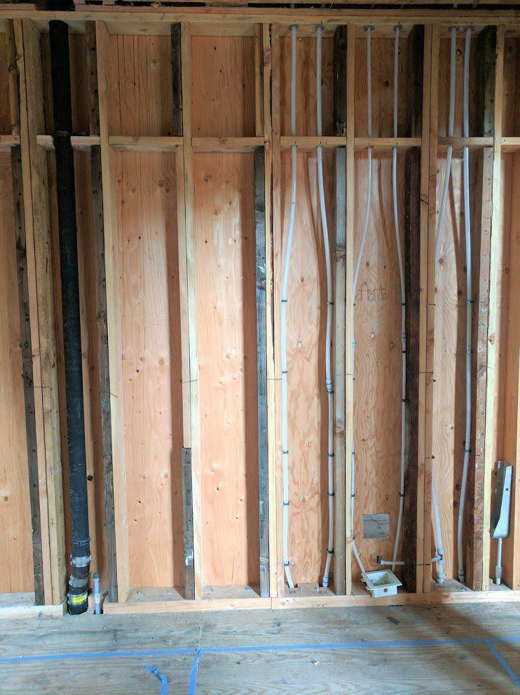 A room with a wooden wall and a wooden floor under construction.