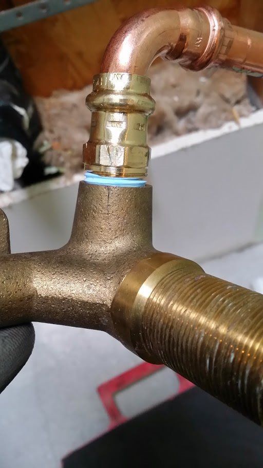 A close up of a brass pipe with a copper pipe attached to it.