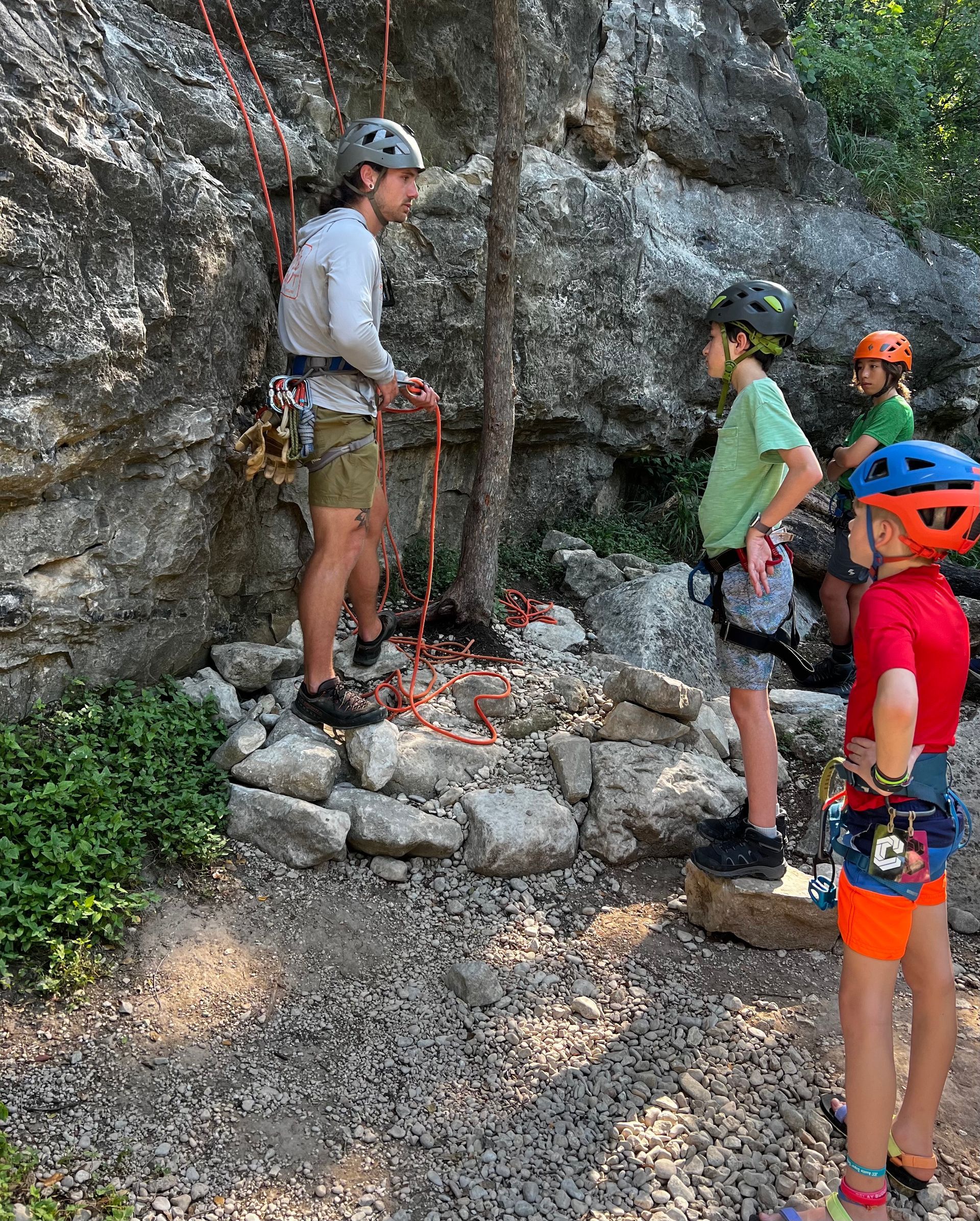 a group of people learning how to rock climb 