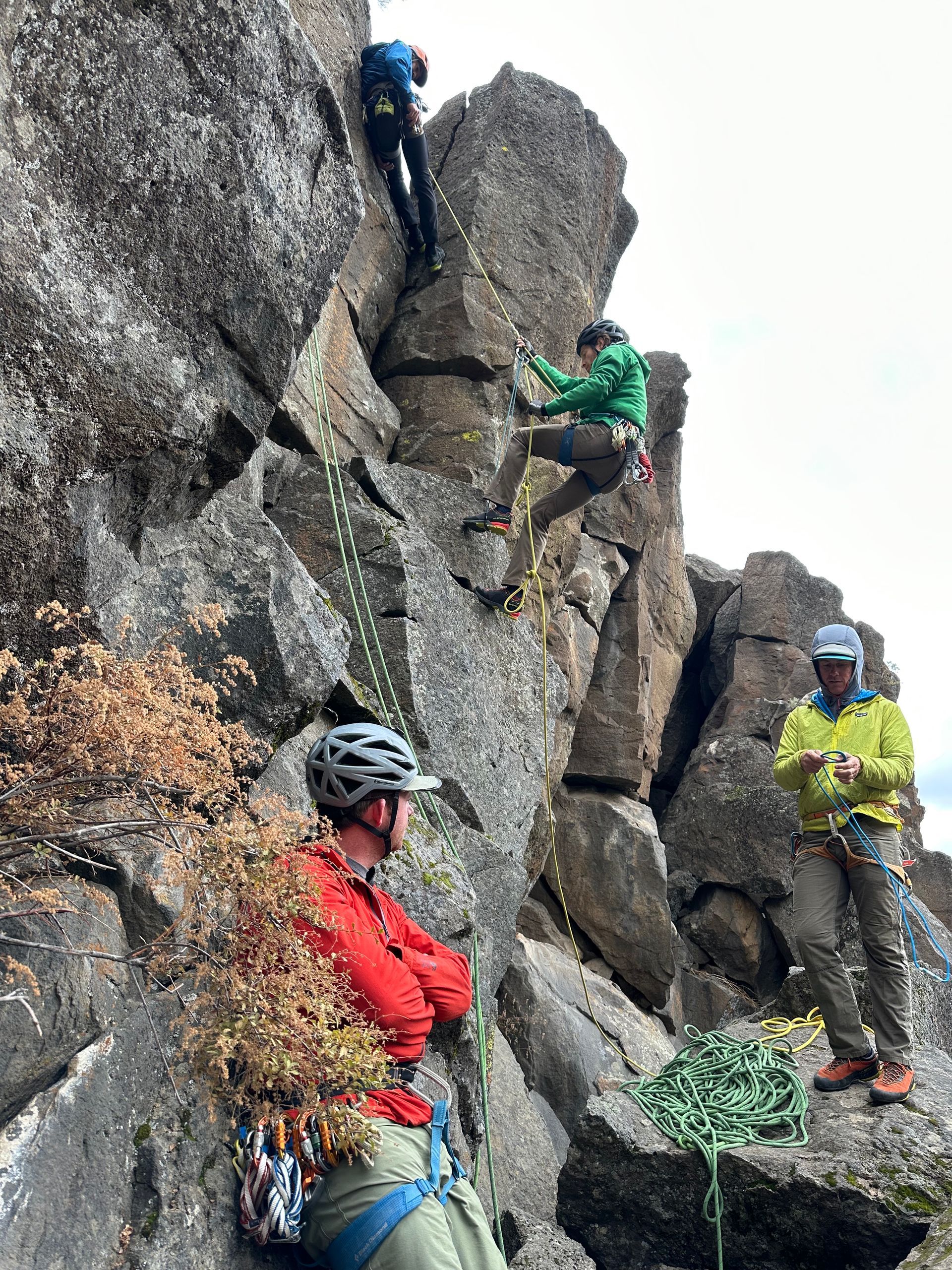 A group of people are climbing up a rocky cliff.