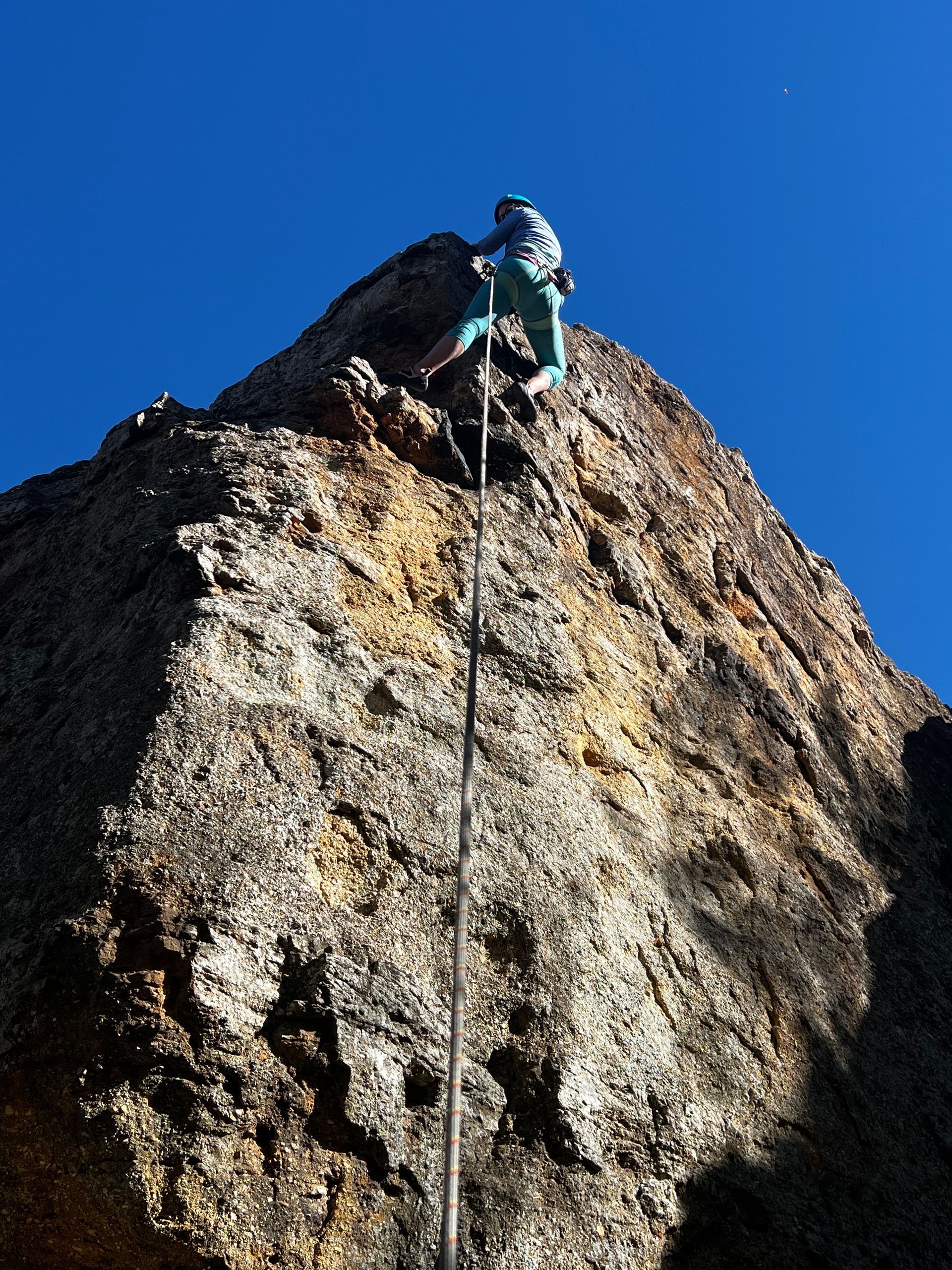 A person scales a rock wall