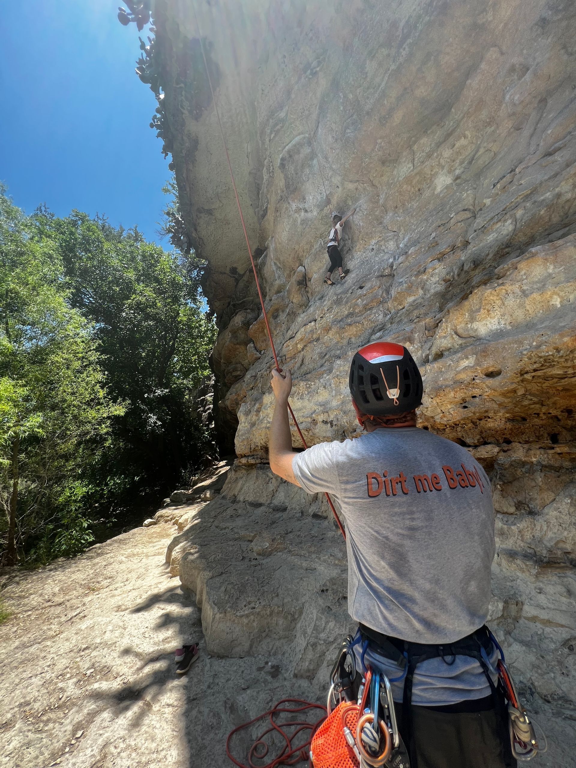 A man wearing a helmet is climbing a rock wall.