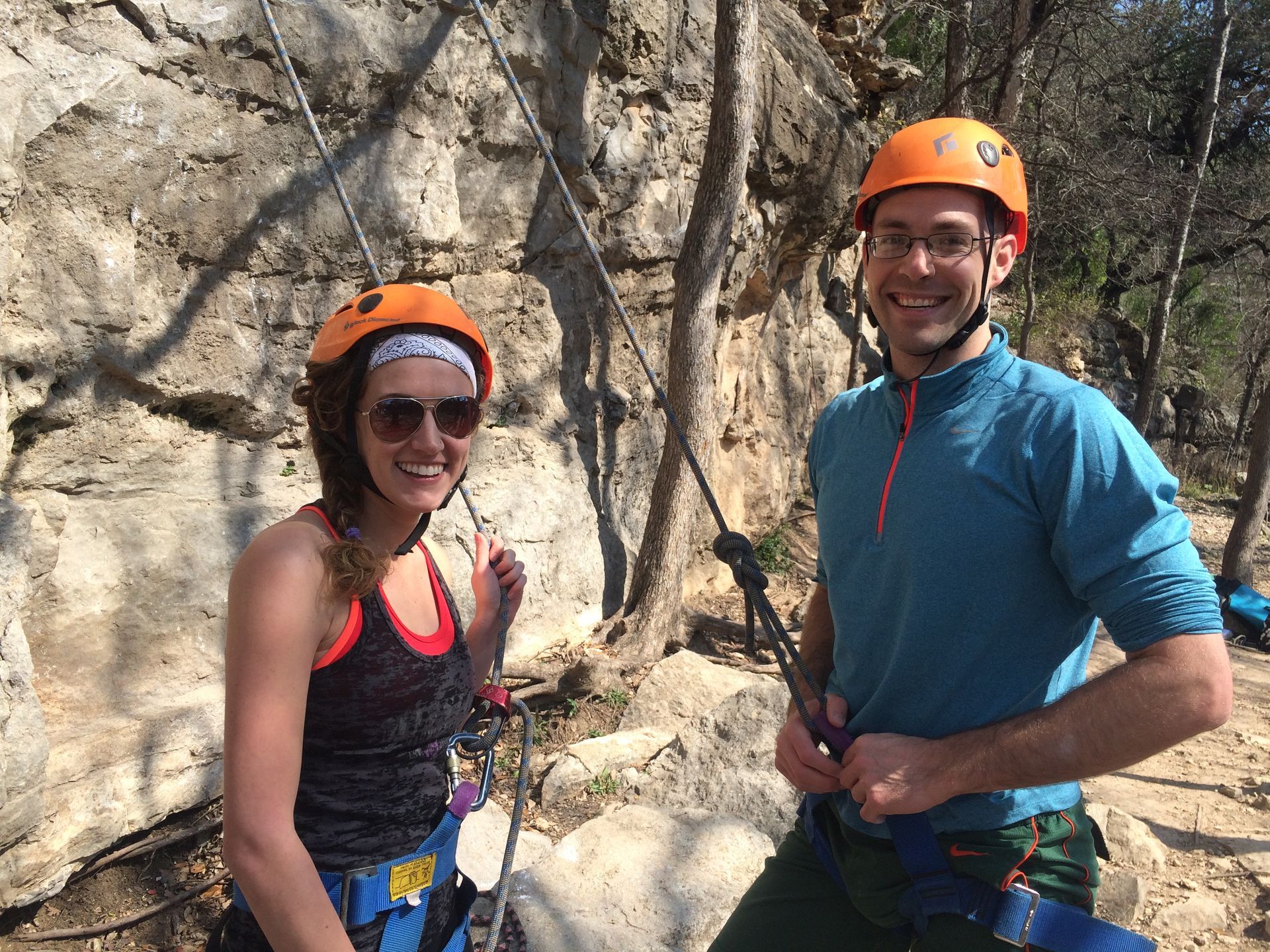 A man and a woman wearing helmets are standing next to each other.