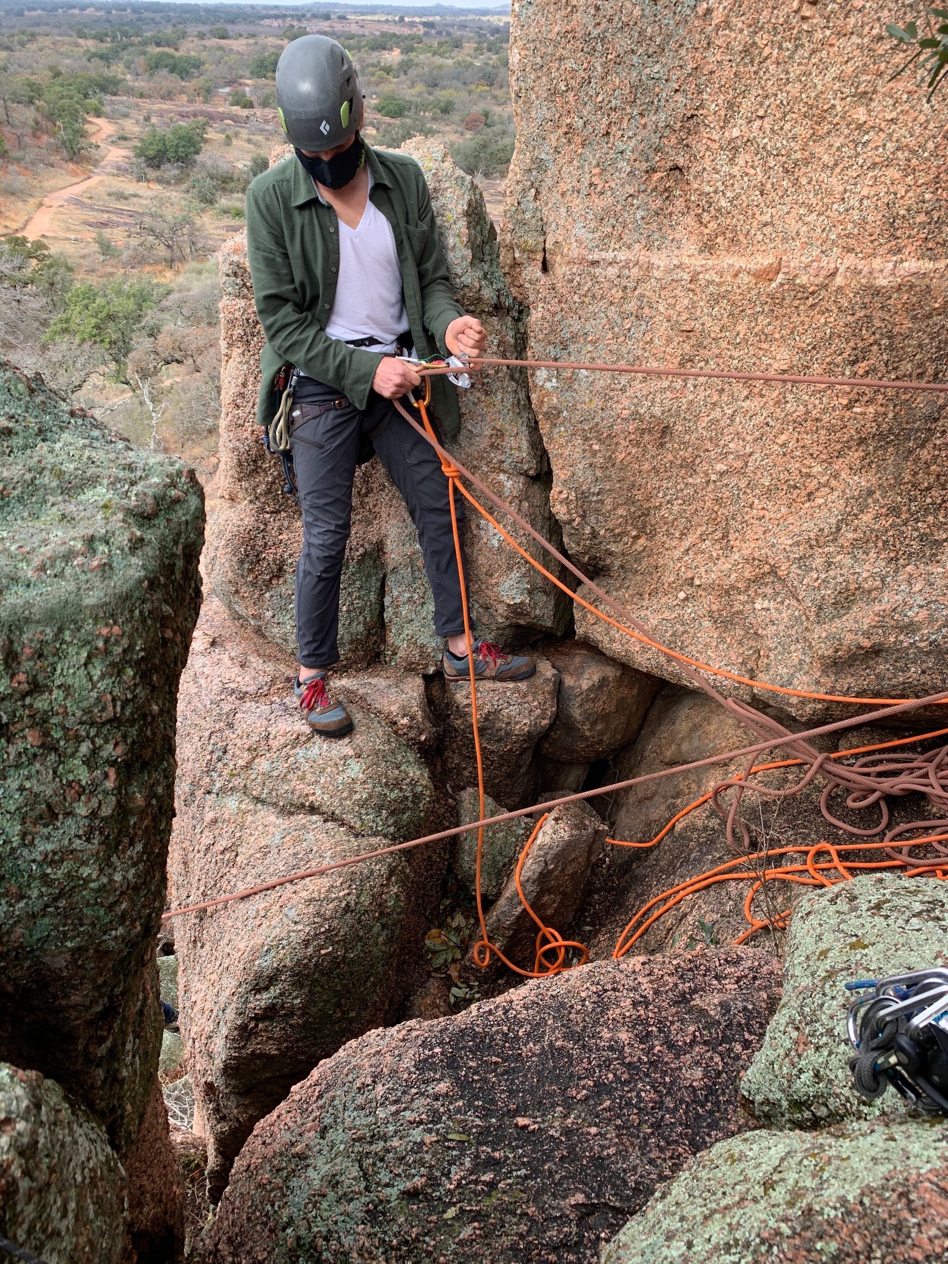 A person works with ropes along a rock face