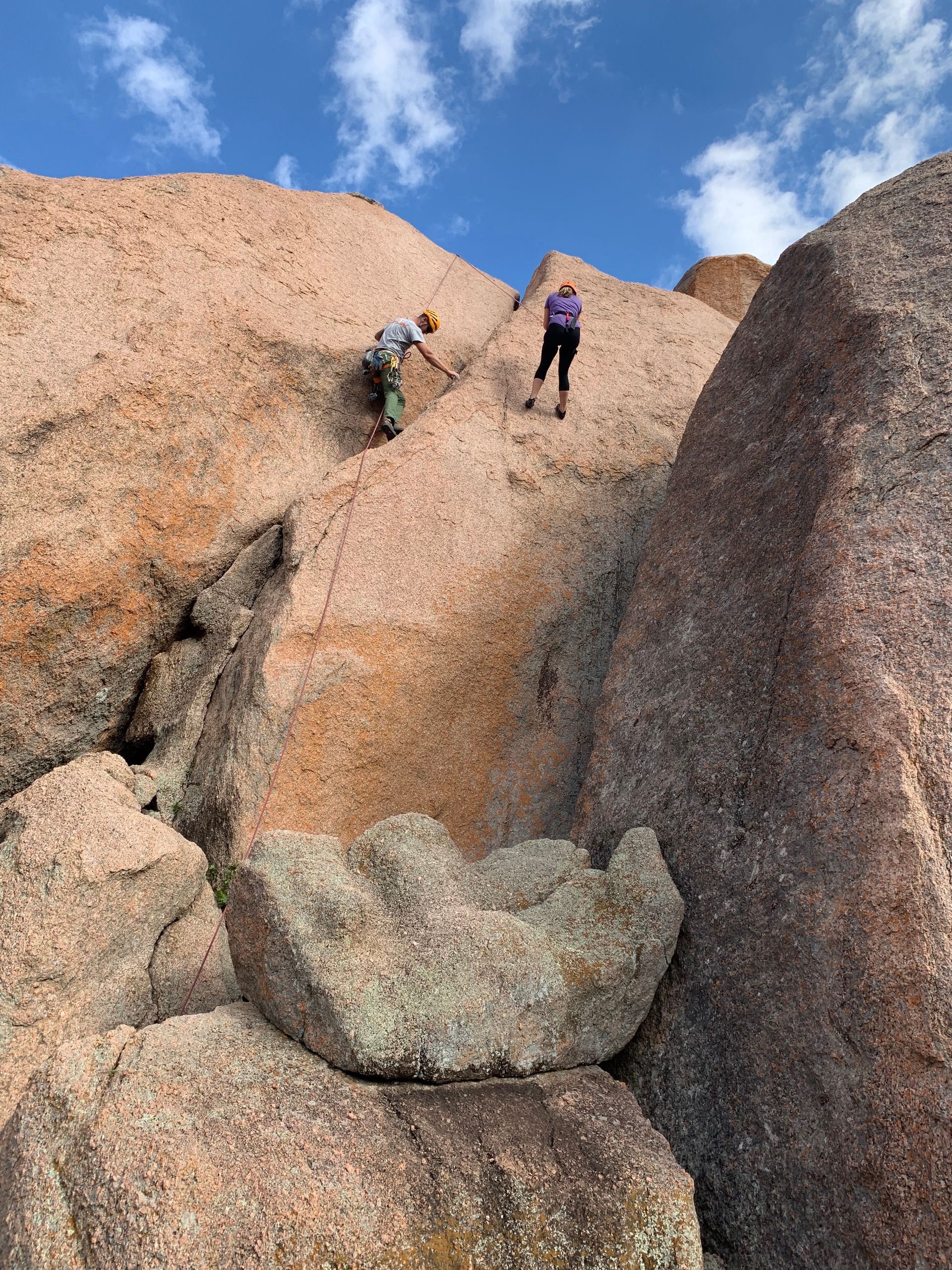 People scale a rock wall