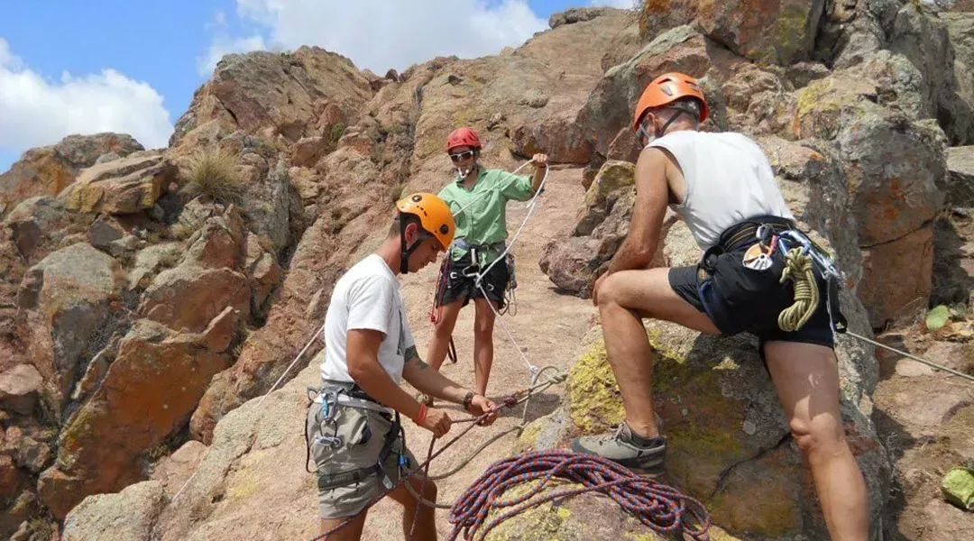 A group of people are climbing a rocky mountain.