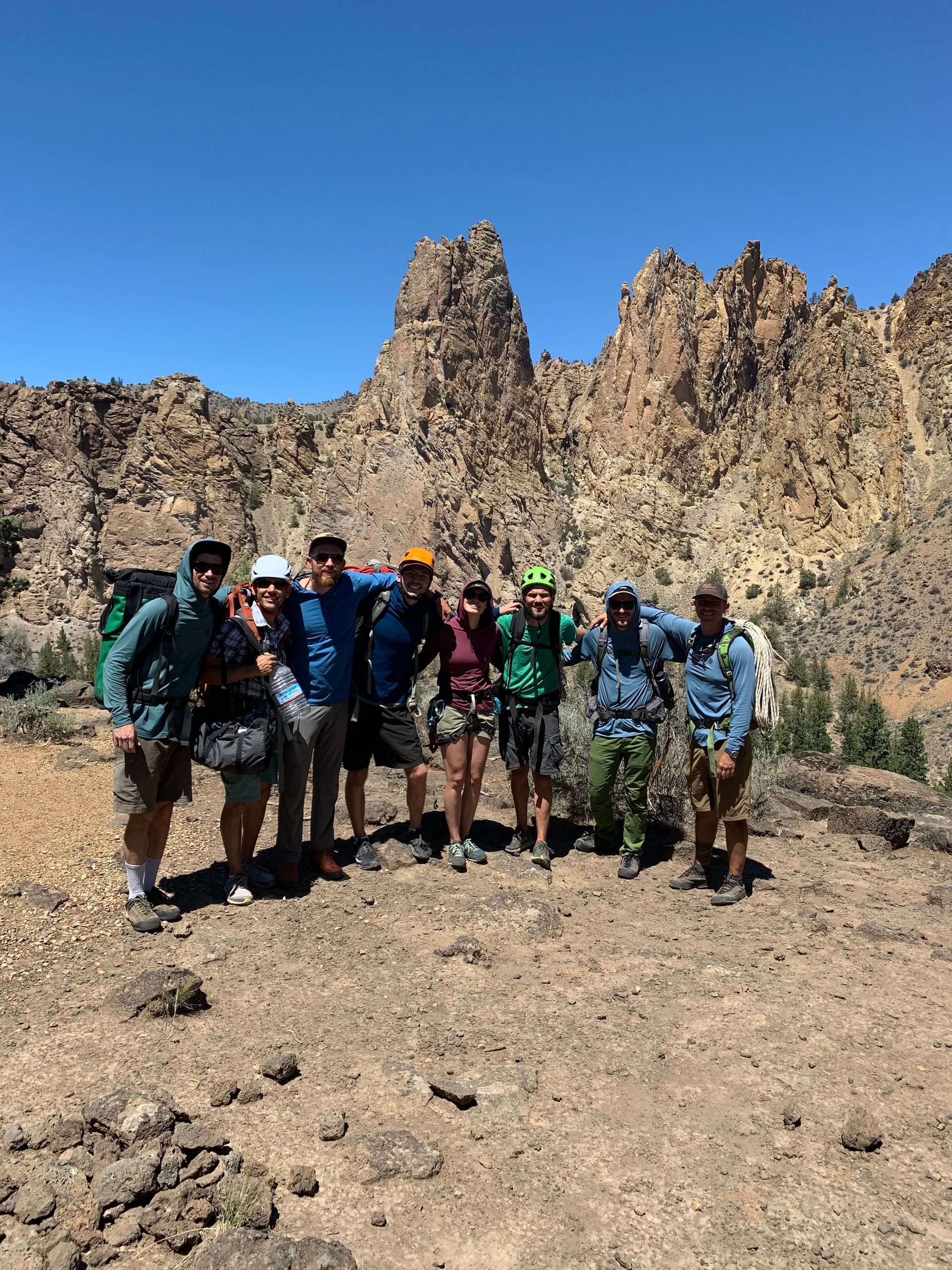 A group of people are posing for a picture in front of a mountain.