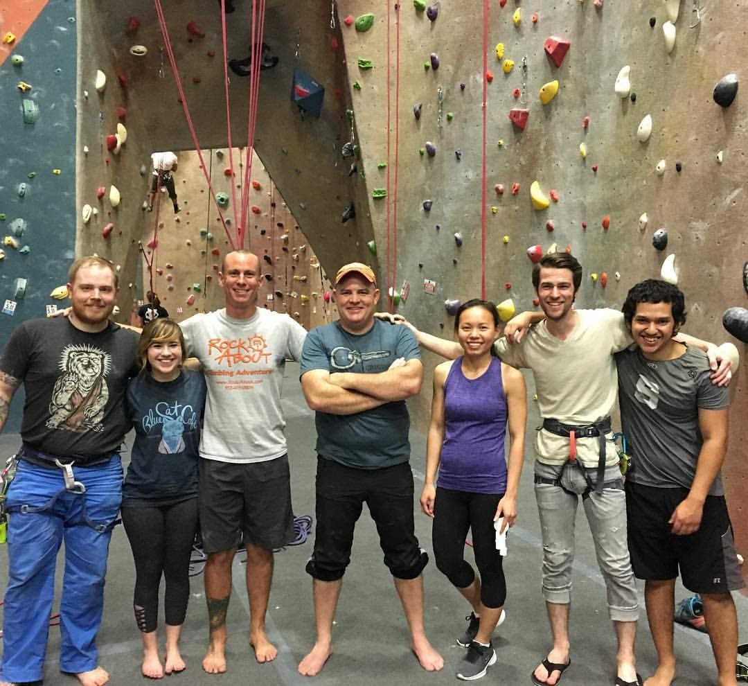 a group of people learning how to rock climb 