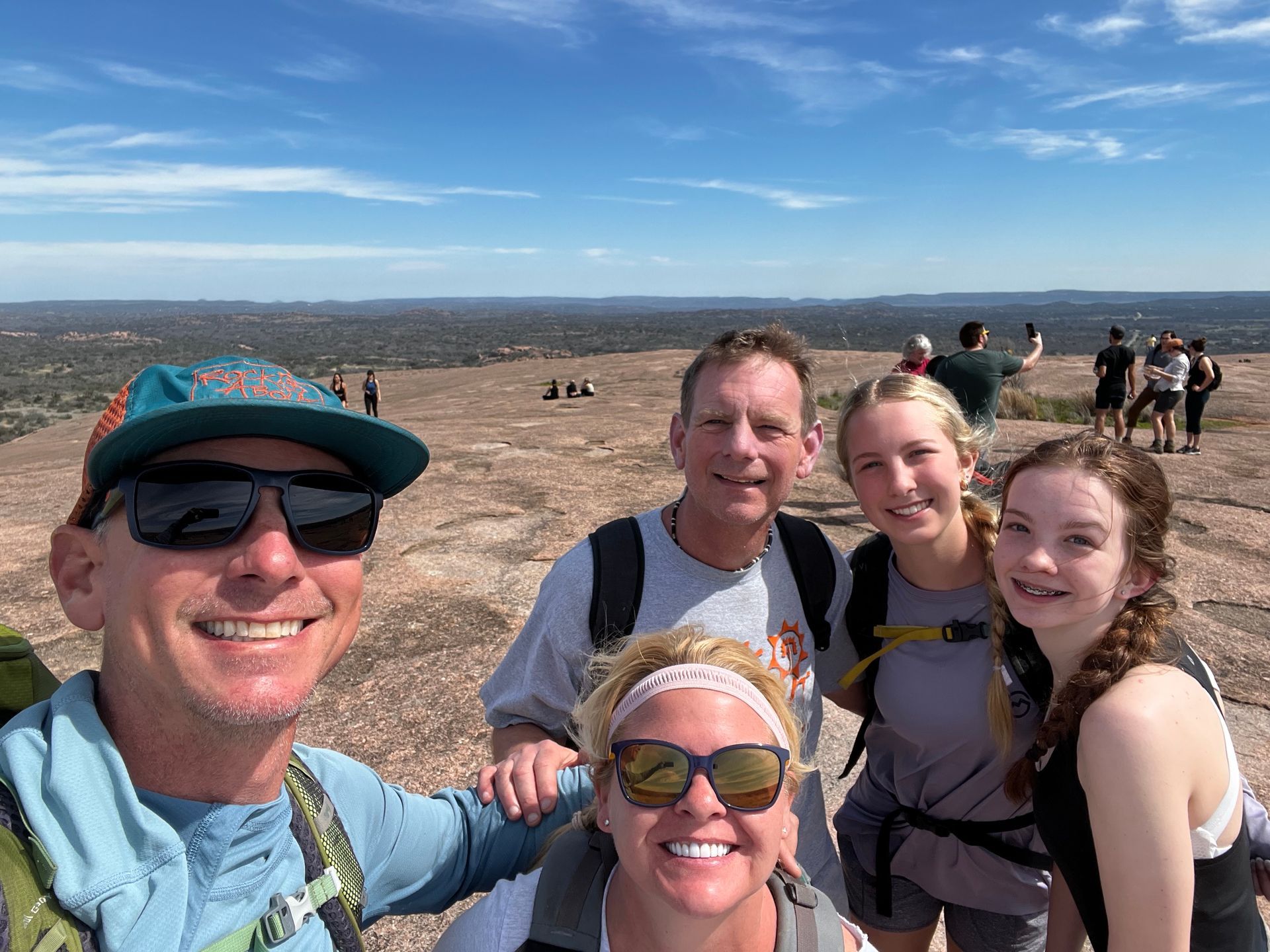 A group of people are posing for a picture on top of a mountain.