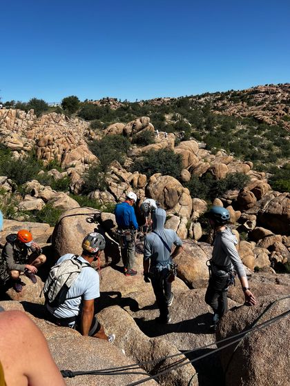 A group of people are standing on top of a rocky hill.