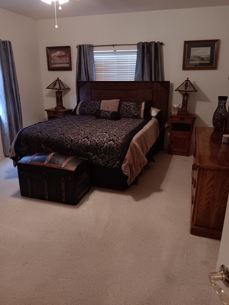 A bedroom with a king size bed and a dresser