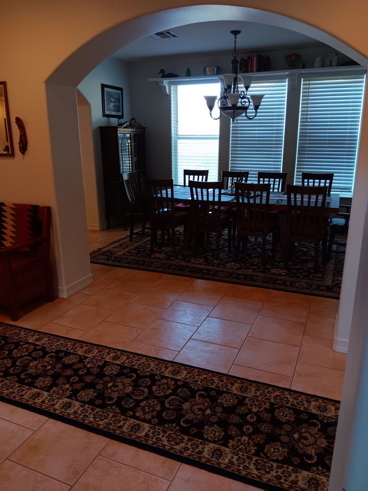 A dining room with a table and chairs and a rug