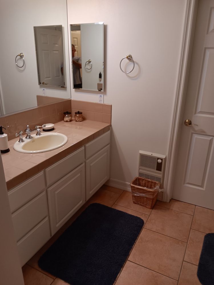 A bathroom with a sink and two mirrors