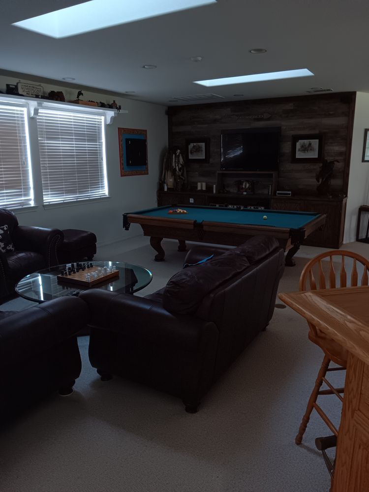A living room with a pool table and a couch