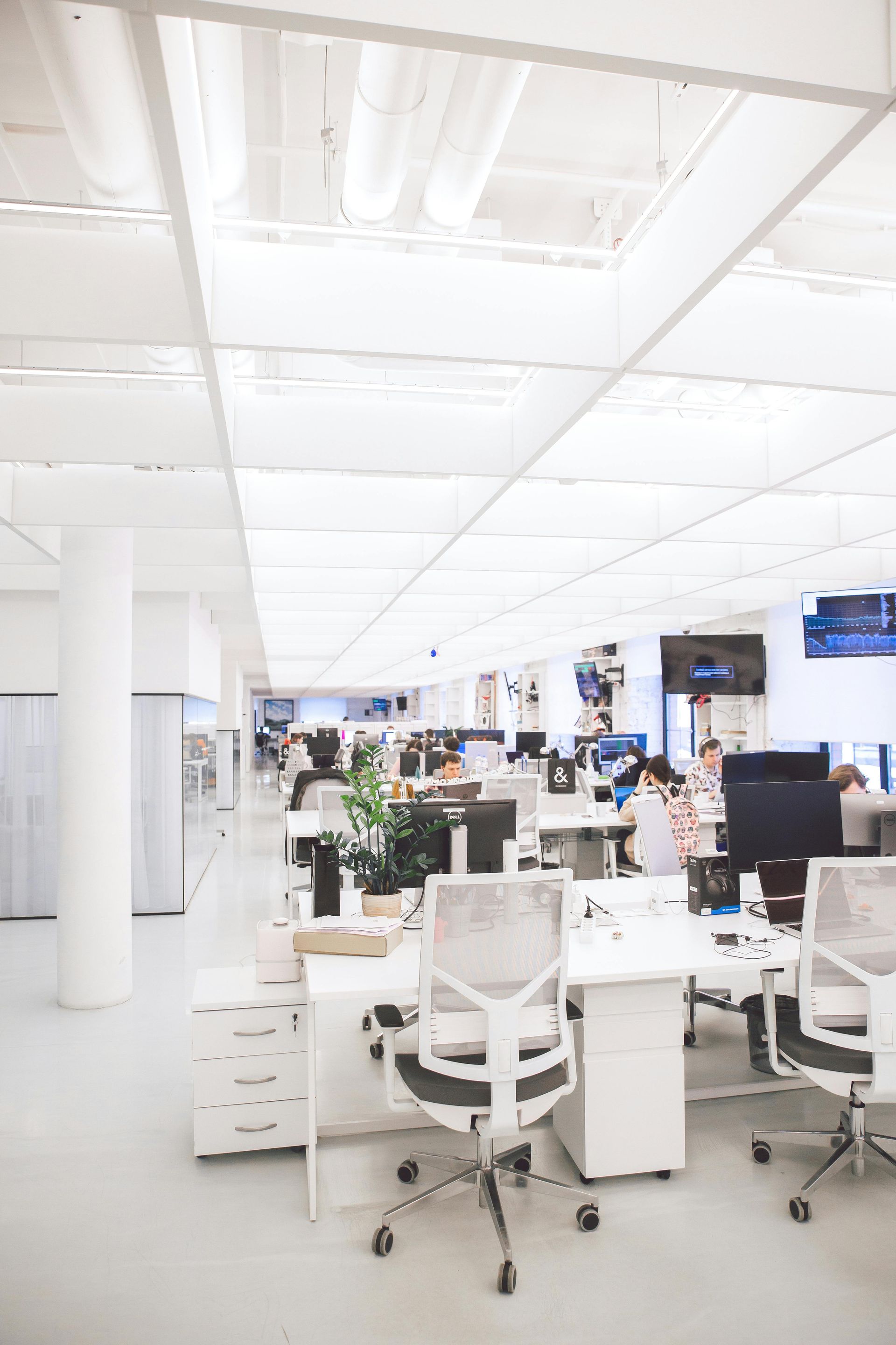 A blurred image of a large office with lots of desks and chairs.