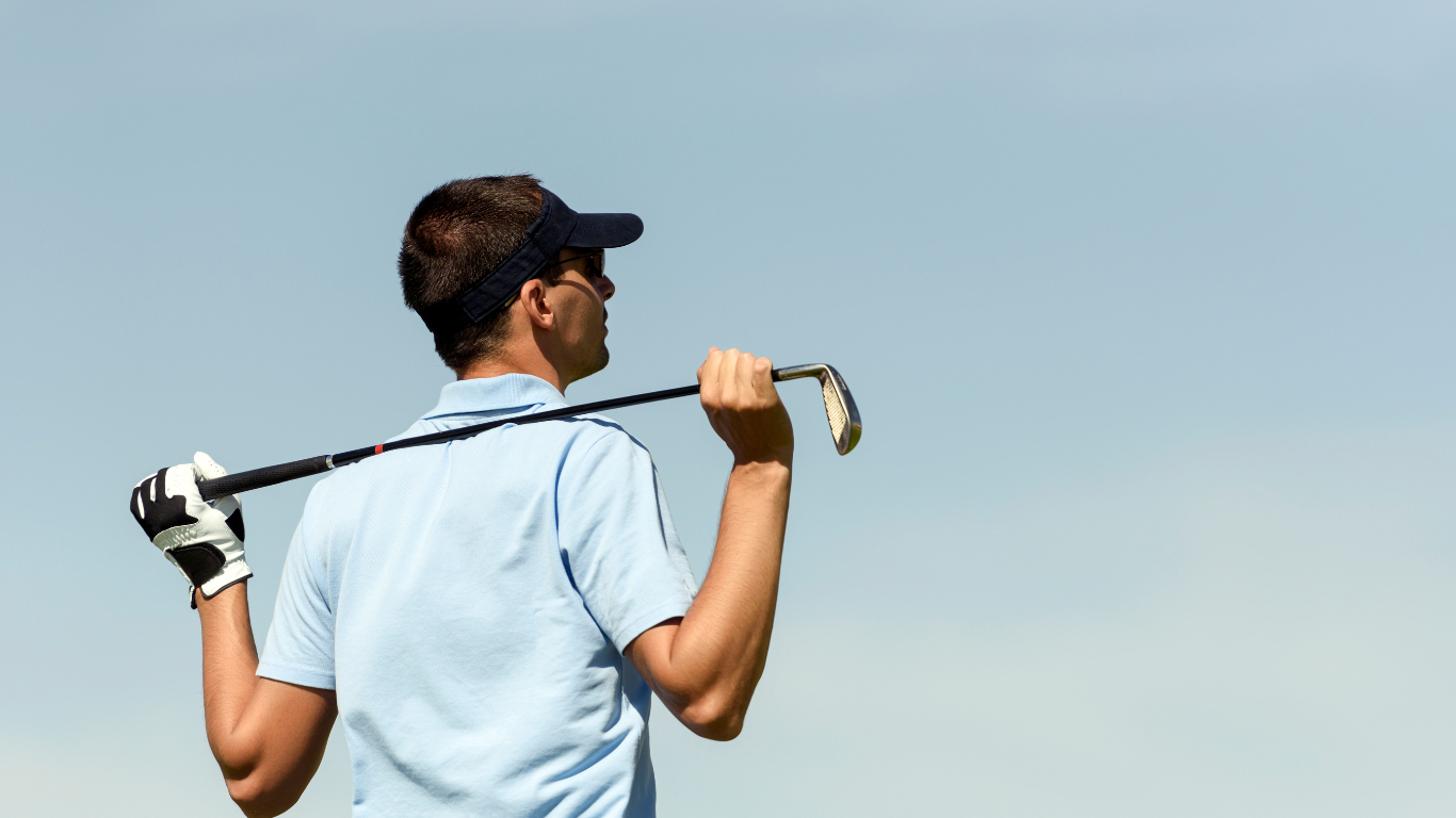 A man is holding a golf club over his shoulder.