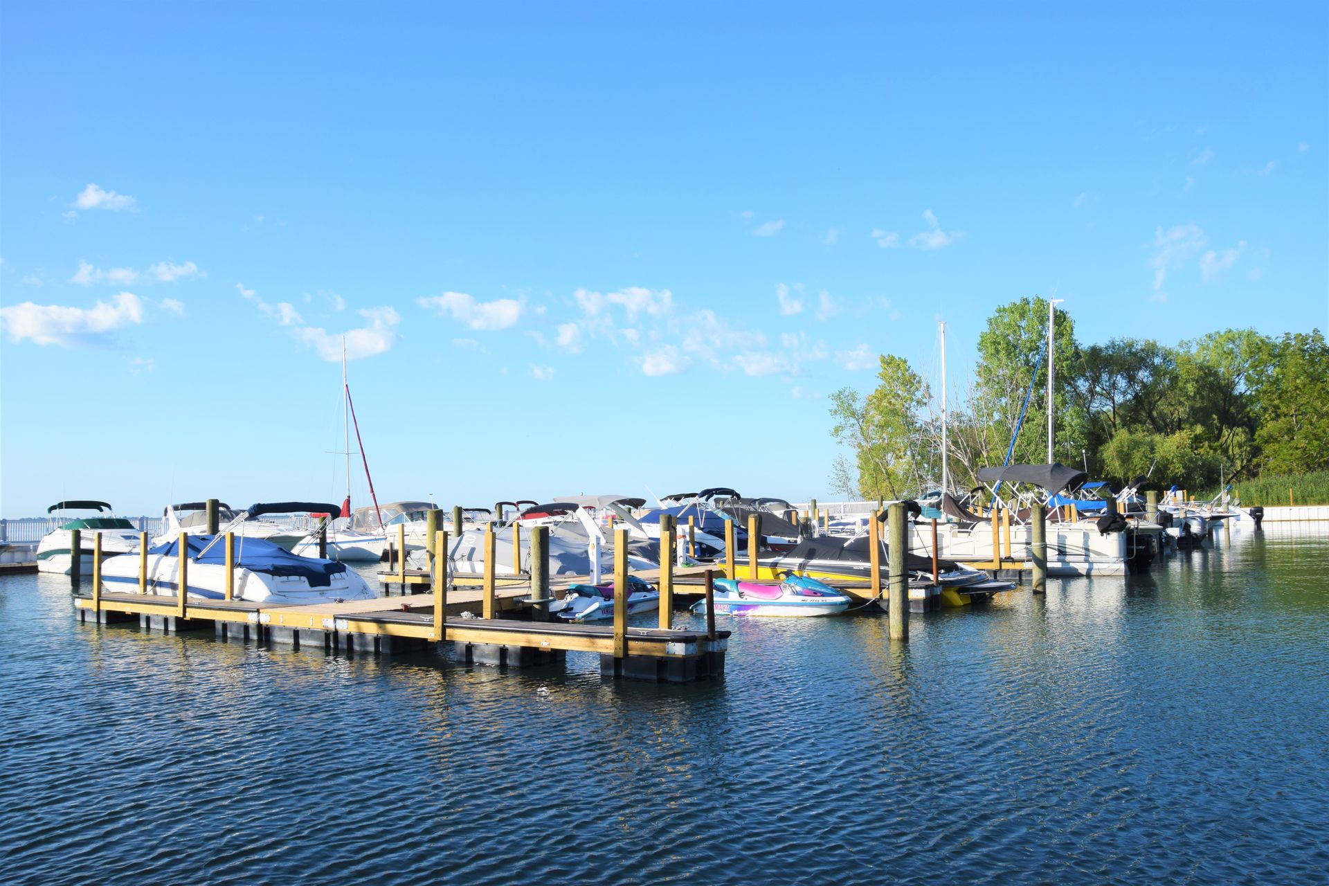 Small marina with docked boats on calm blue water under a clear sky