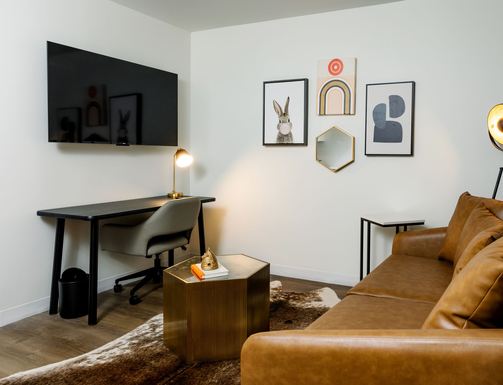 A living room with a couch , desk , and television.