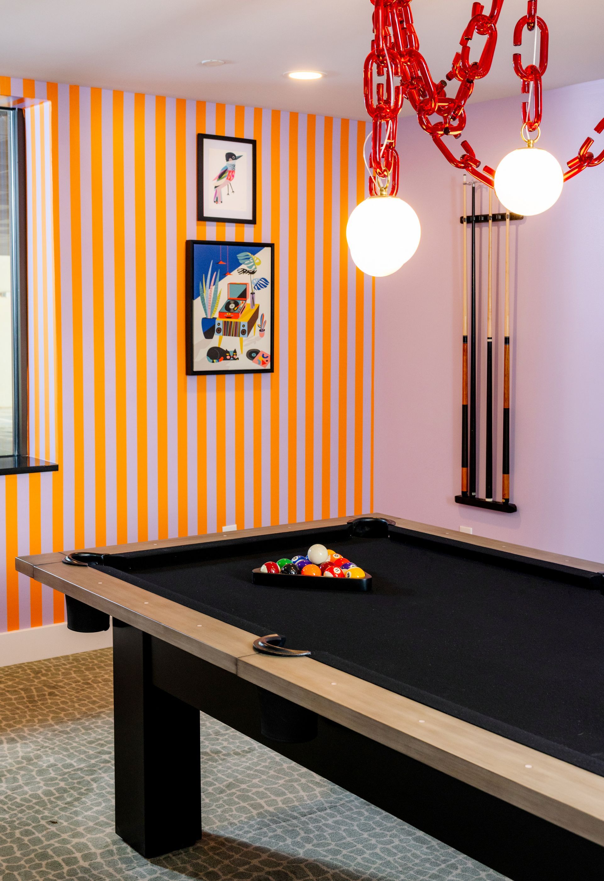 A pool table in a room with striped walls