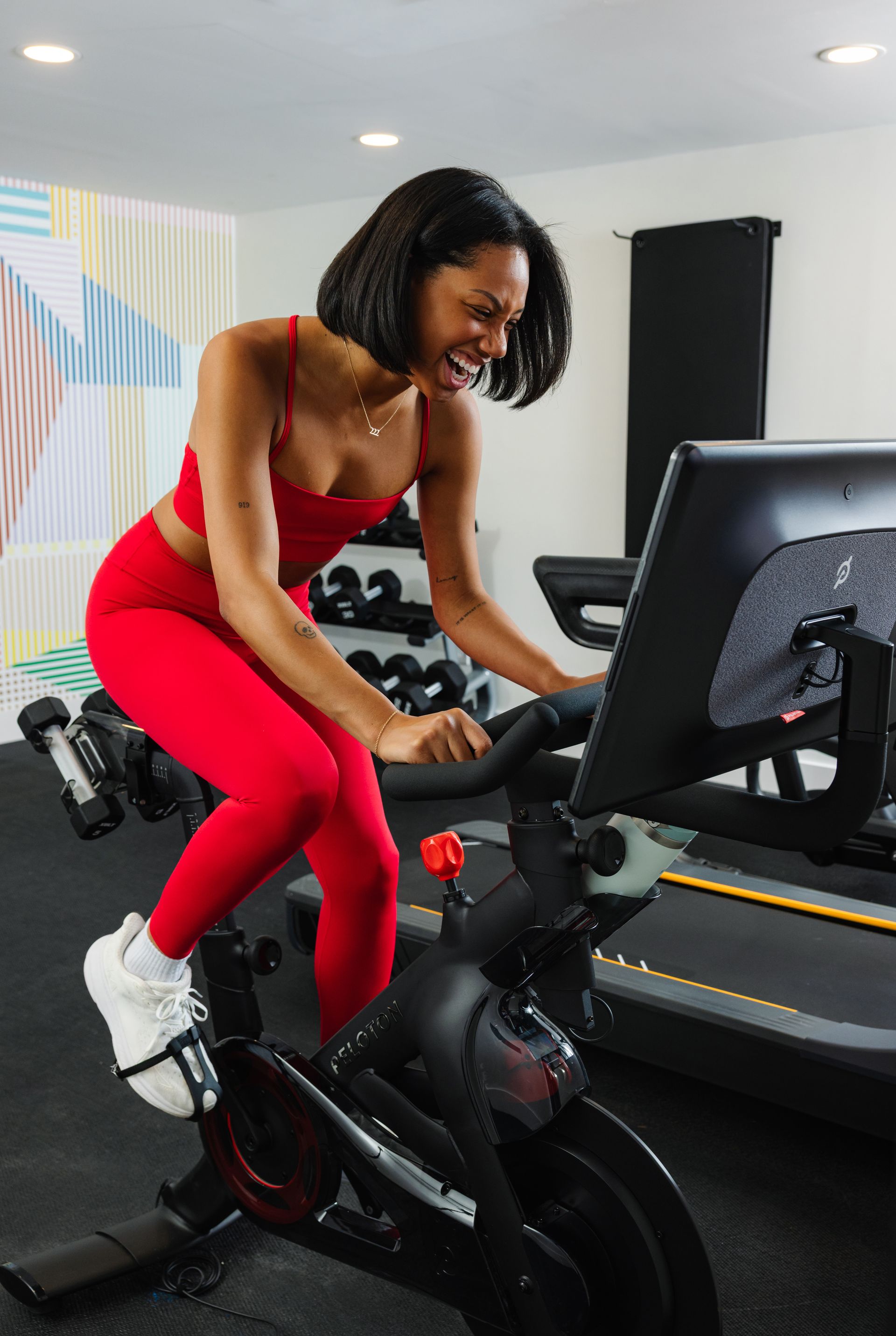 A woman is riding an exercise bike in a gym.