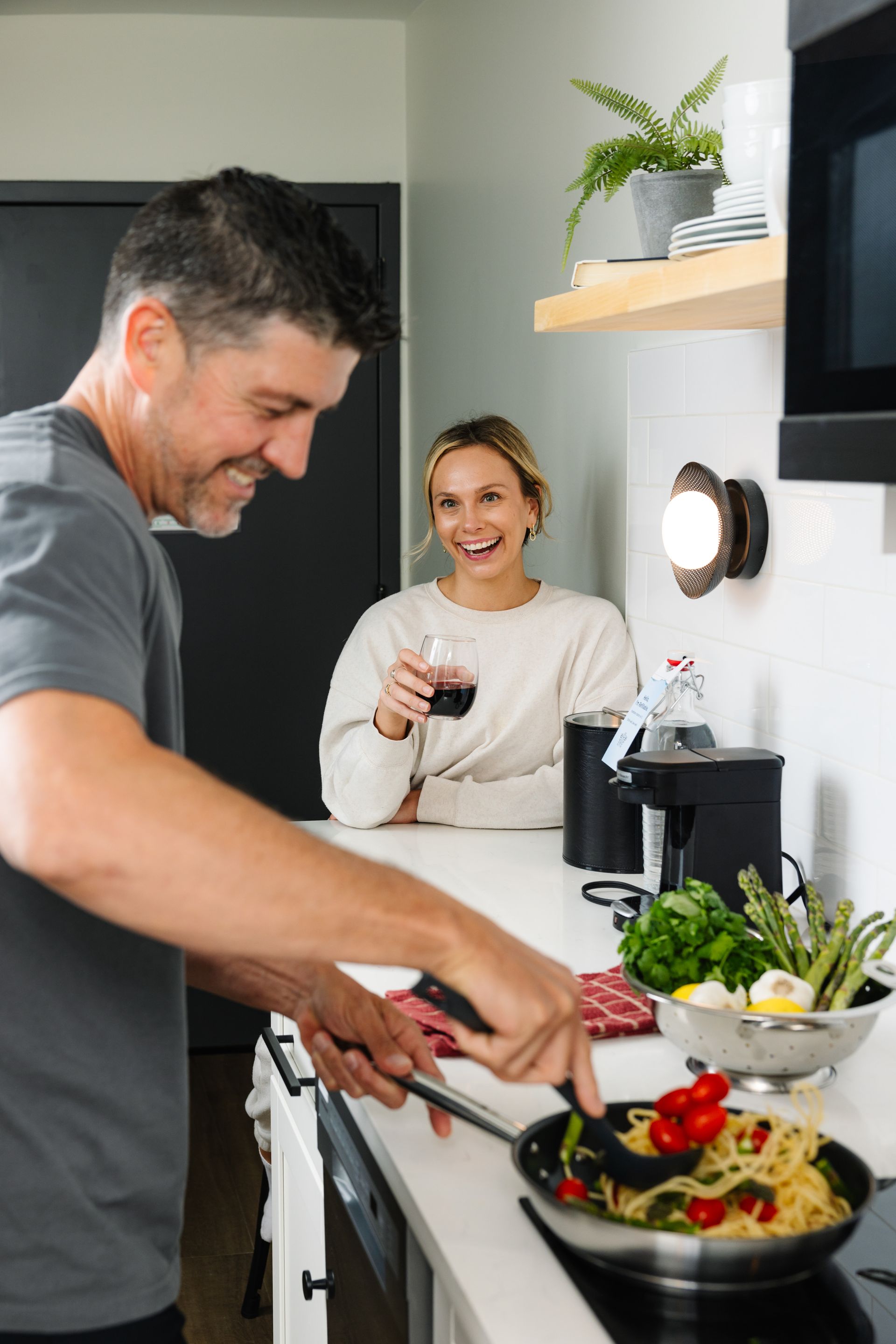 A man and a woman are cooking together in a kitchen.