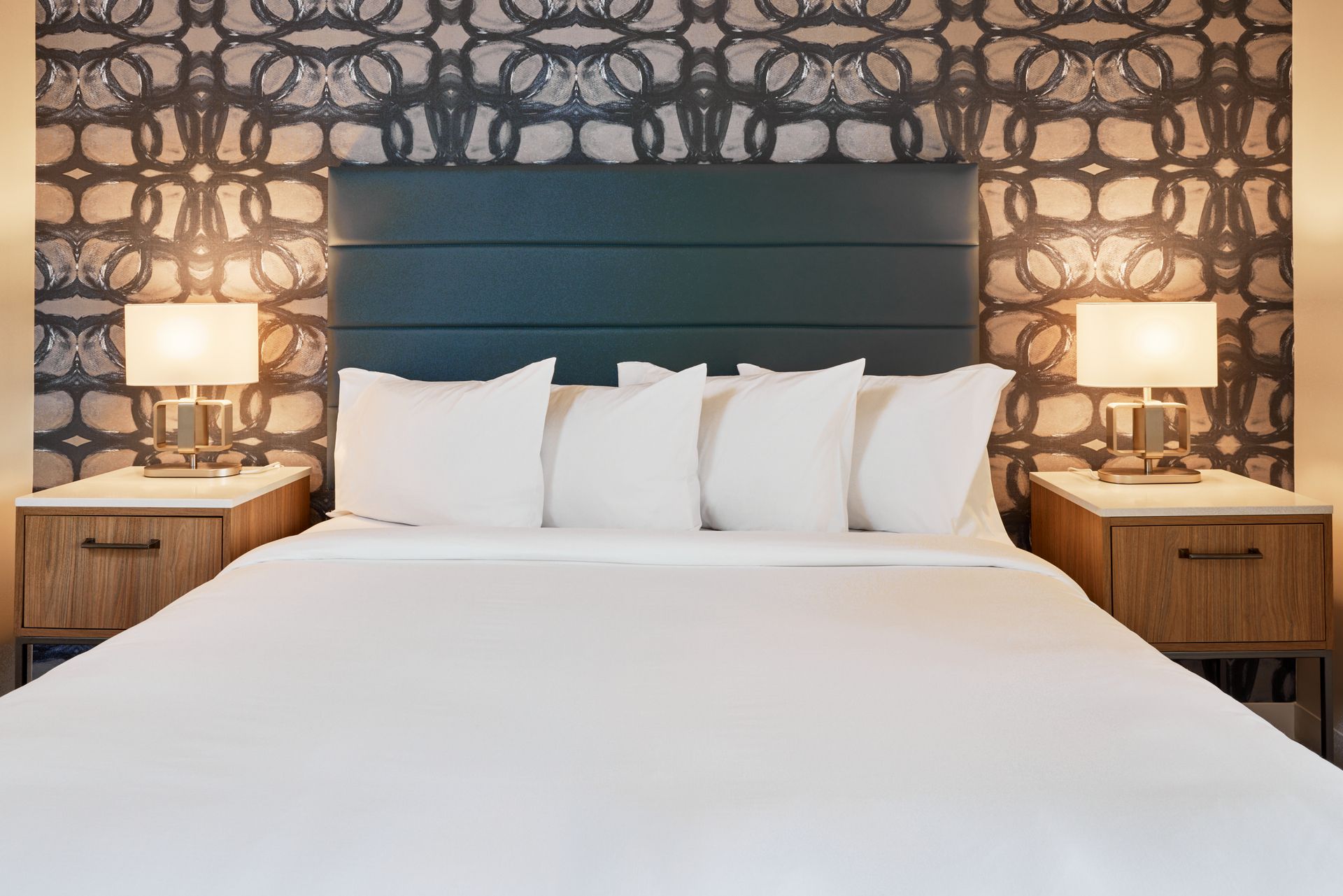 A hotel room with a king size bed and two nightstands.
