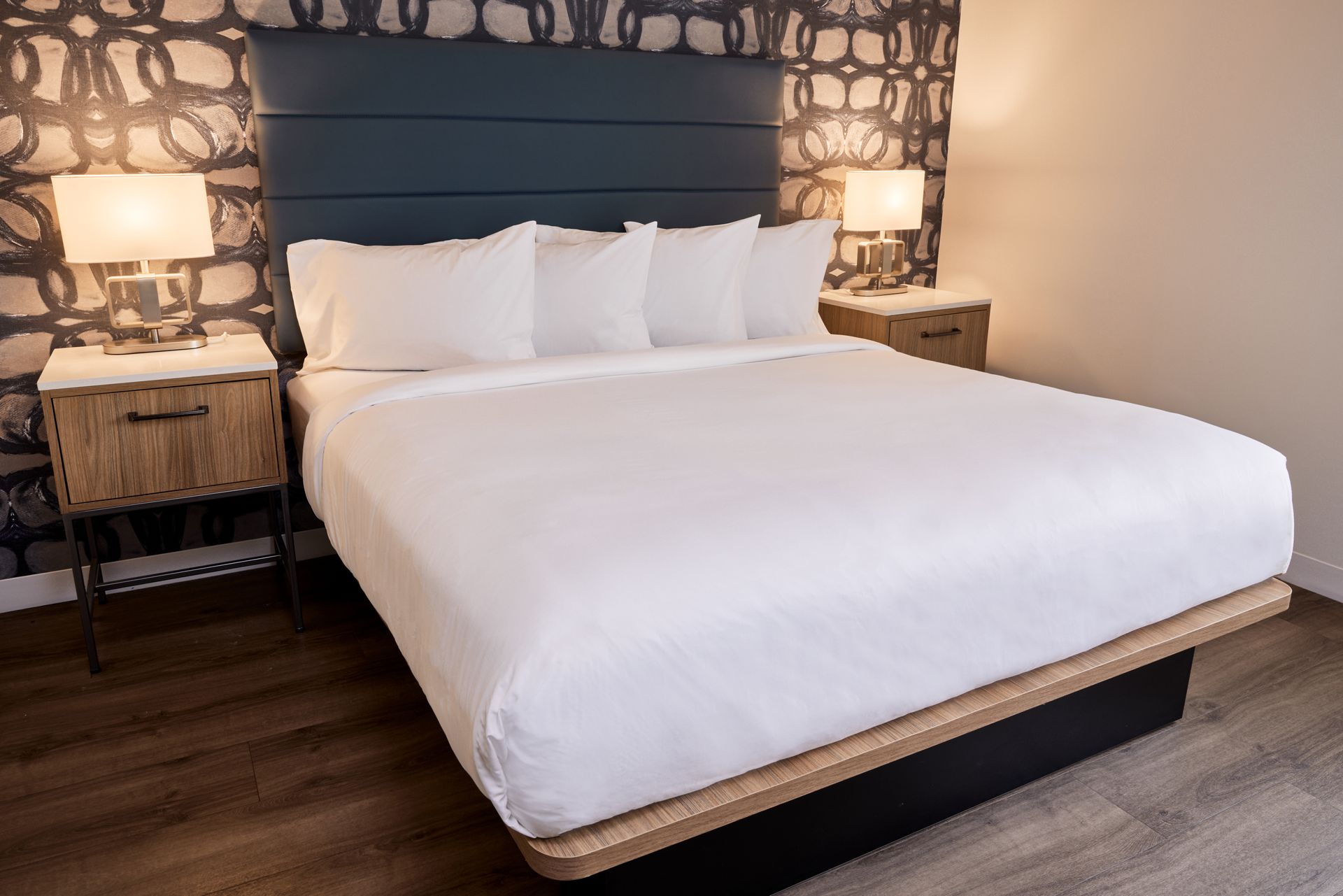 A hotel room with a king size bed and two nightstands.