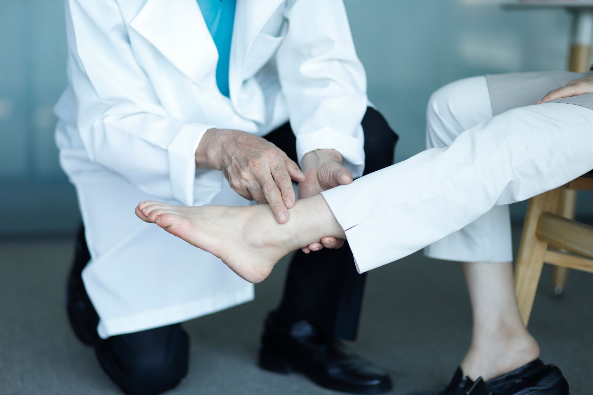 A doctor is examining the ankle of a patient.