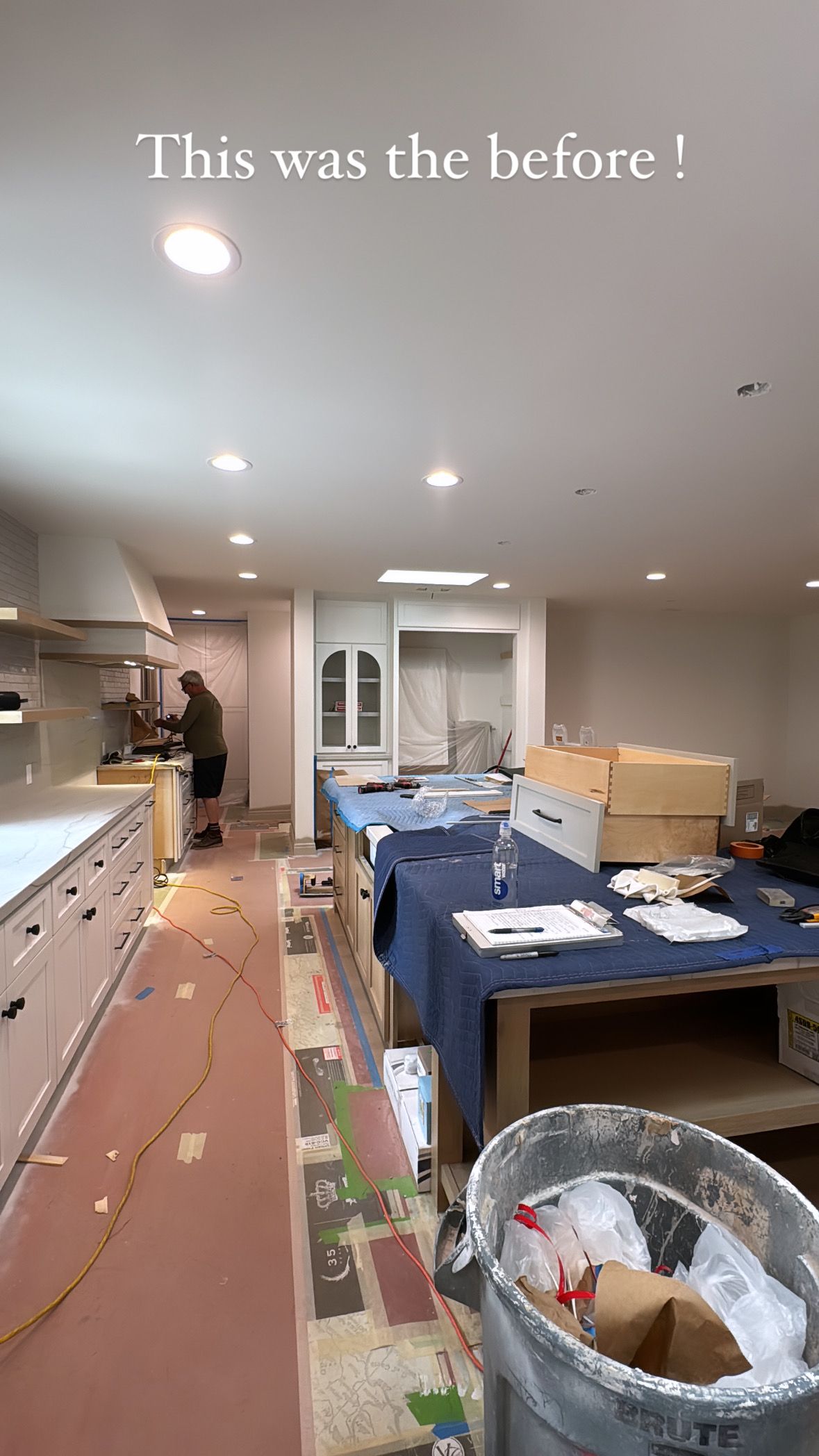 A kitchen is being remodeled and there is a trash can in the middle of the room.