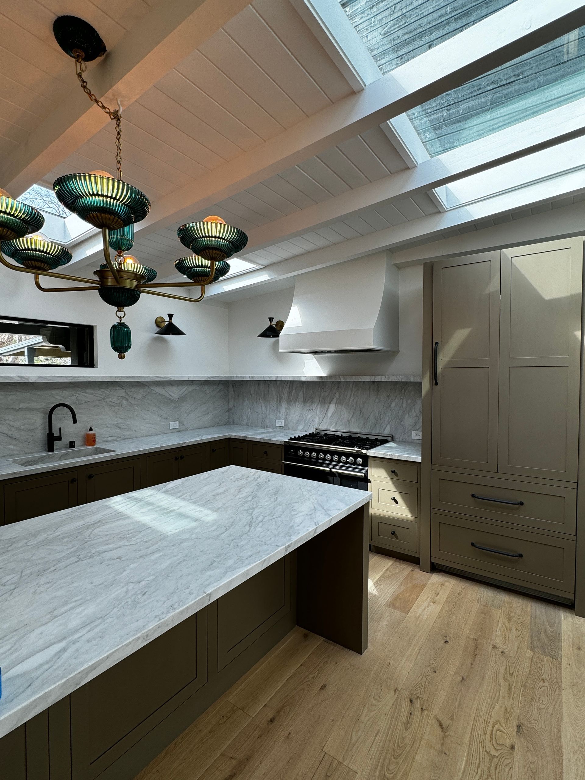 A kitchen with a large island and a chandelier hanging from the ceiling