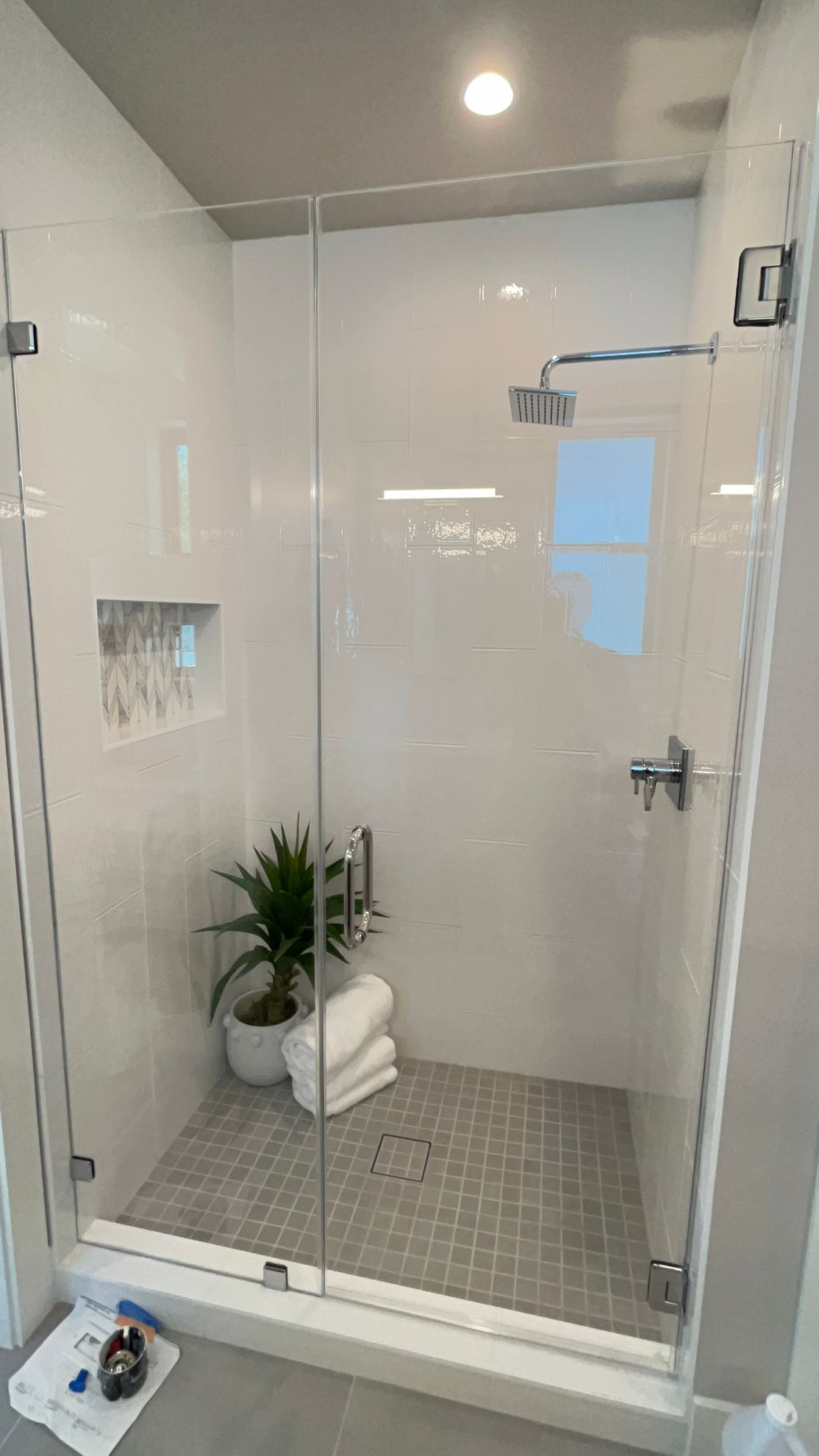 A bathroom with a walk in shower with a glass door.