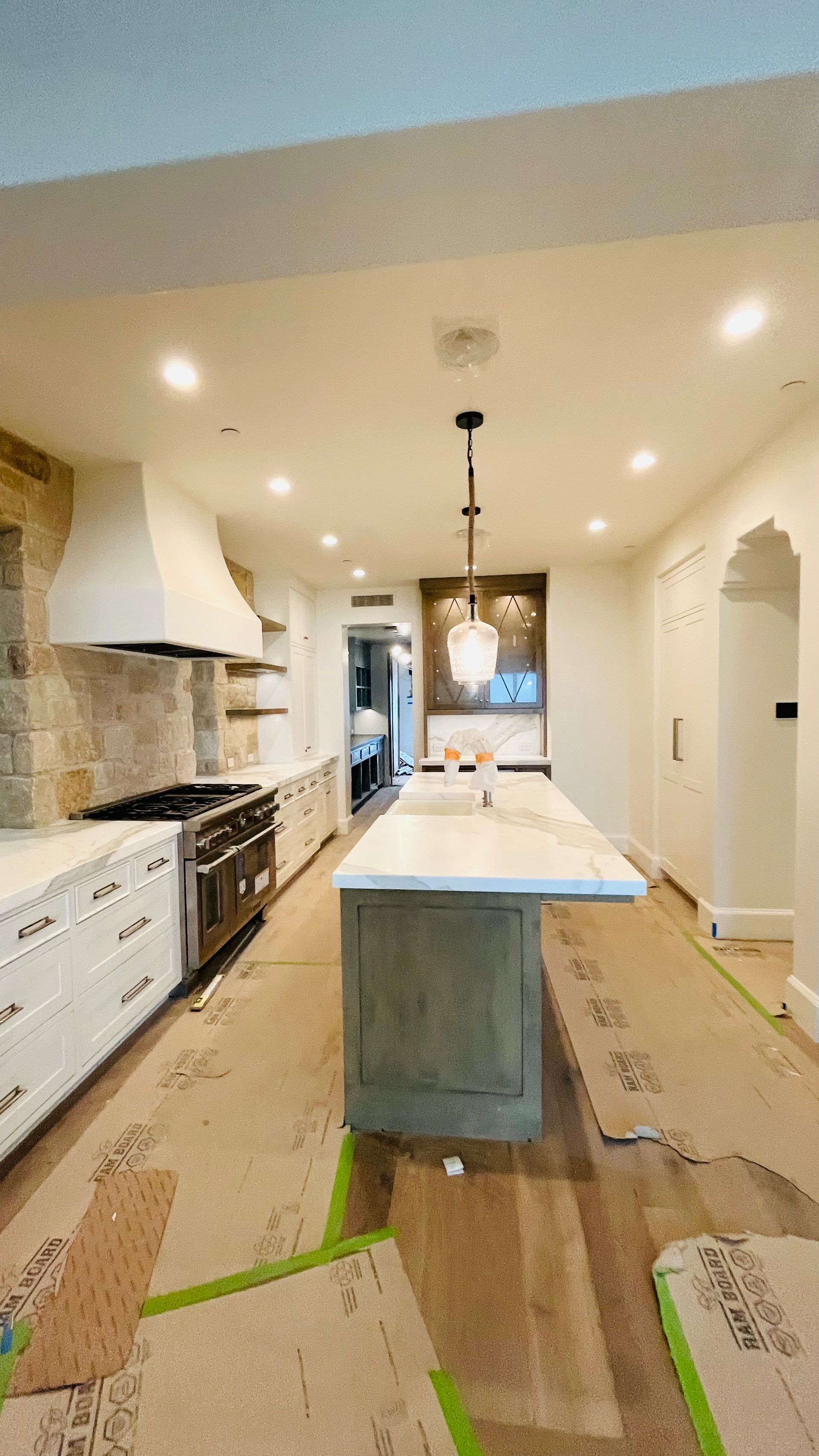 A kitchen under construction with a large island in the middle.