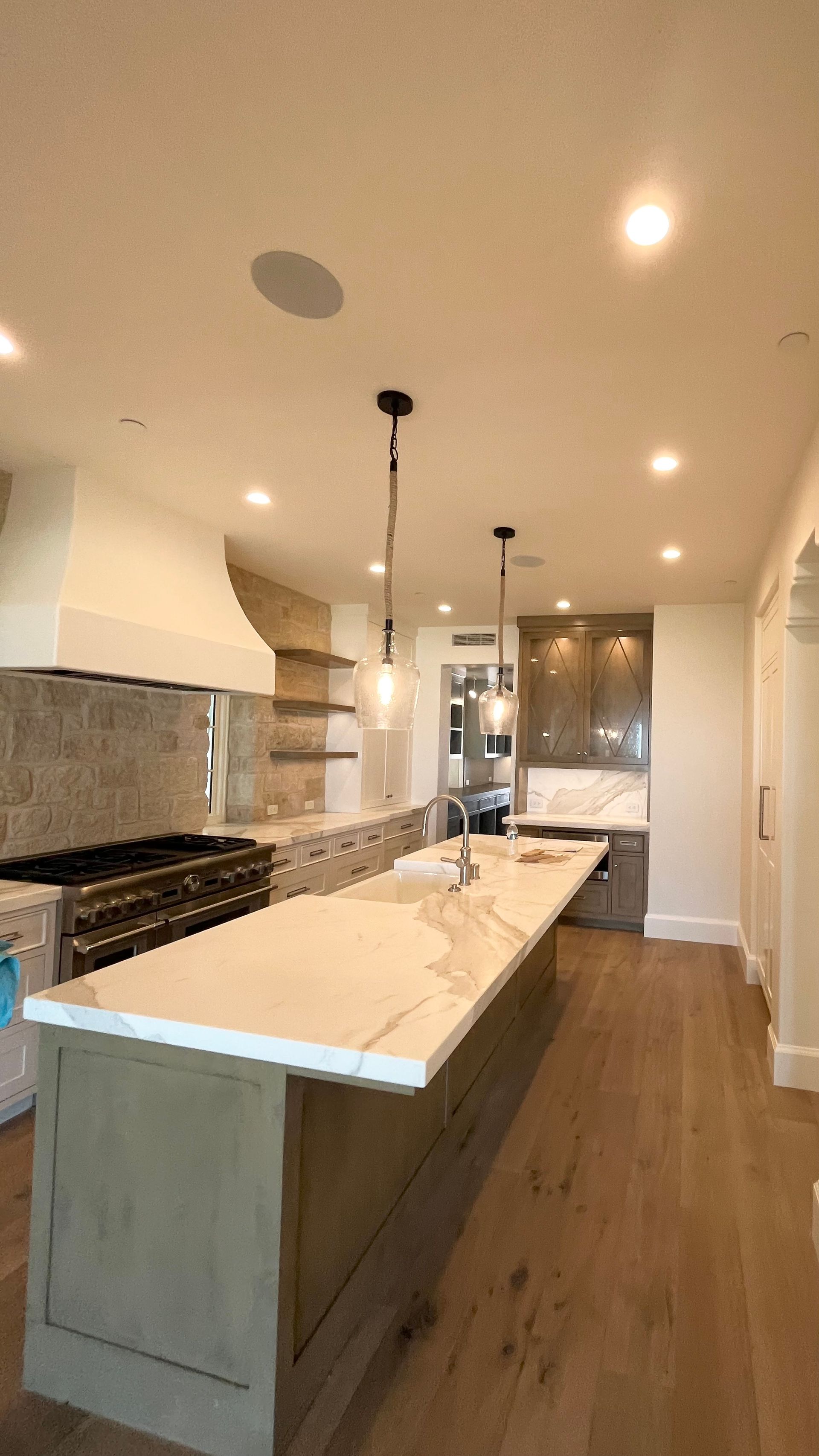 A kitchen with a large island and a stove top oven.