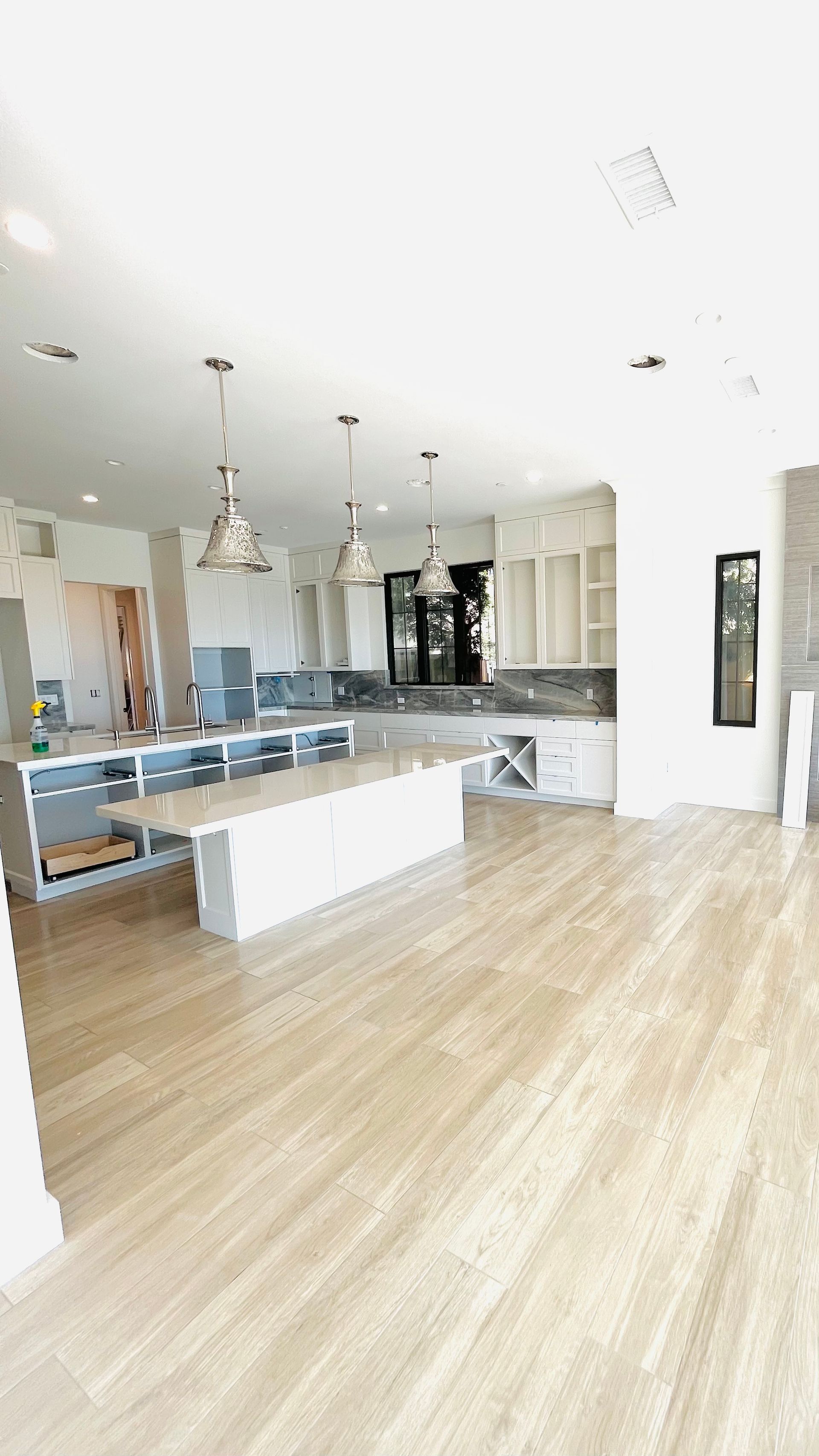 A large kitchen with hardwood floors and white cabinets.