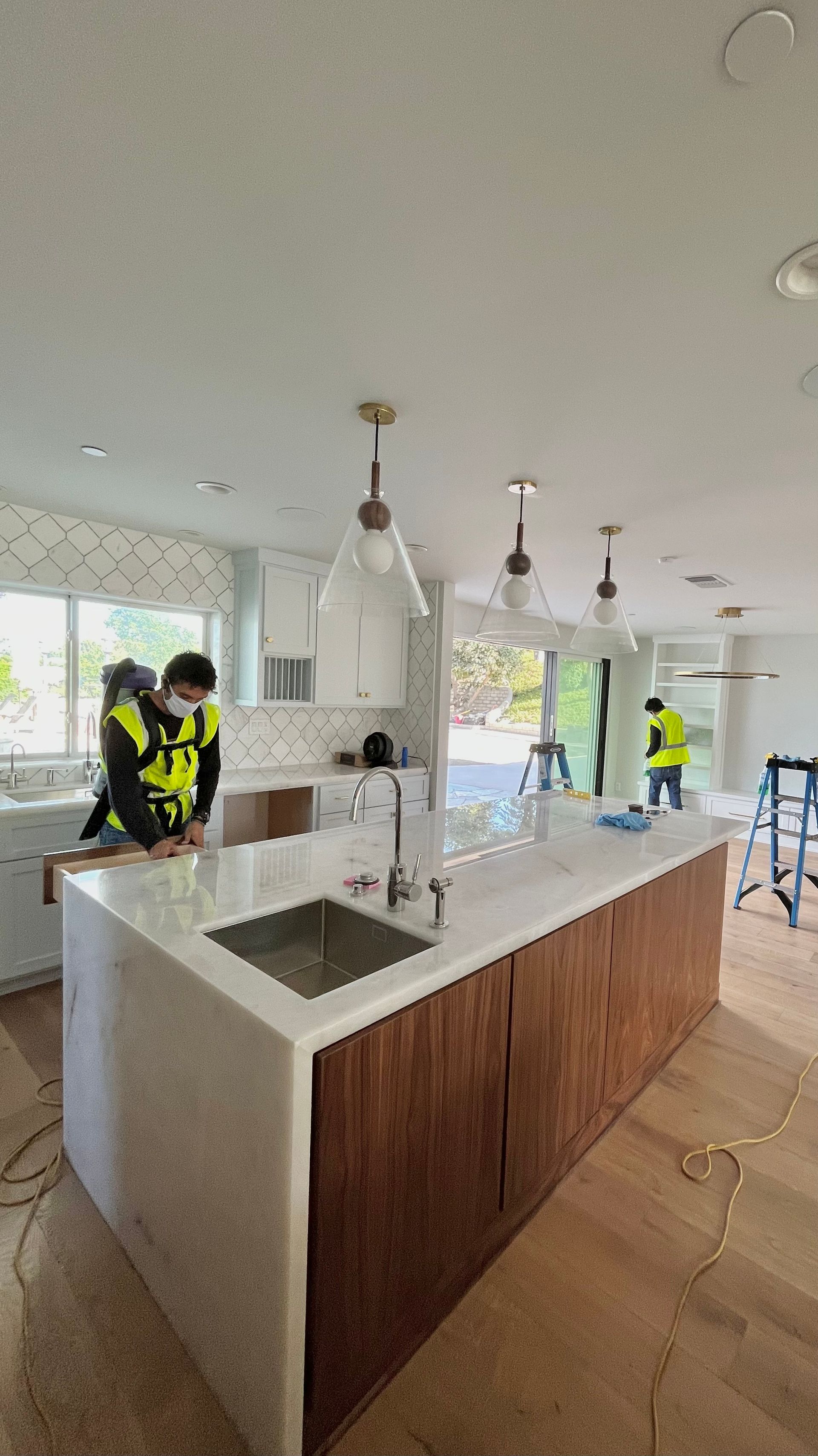 A kitchen under construction with a large island and a sink.