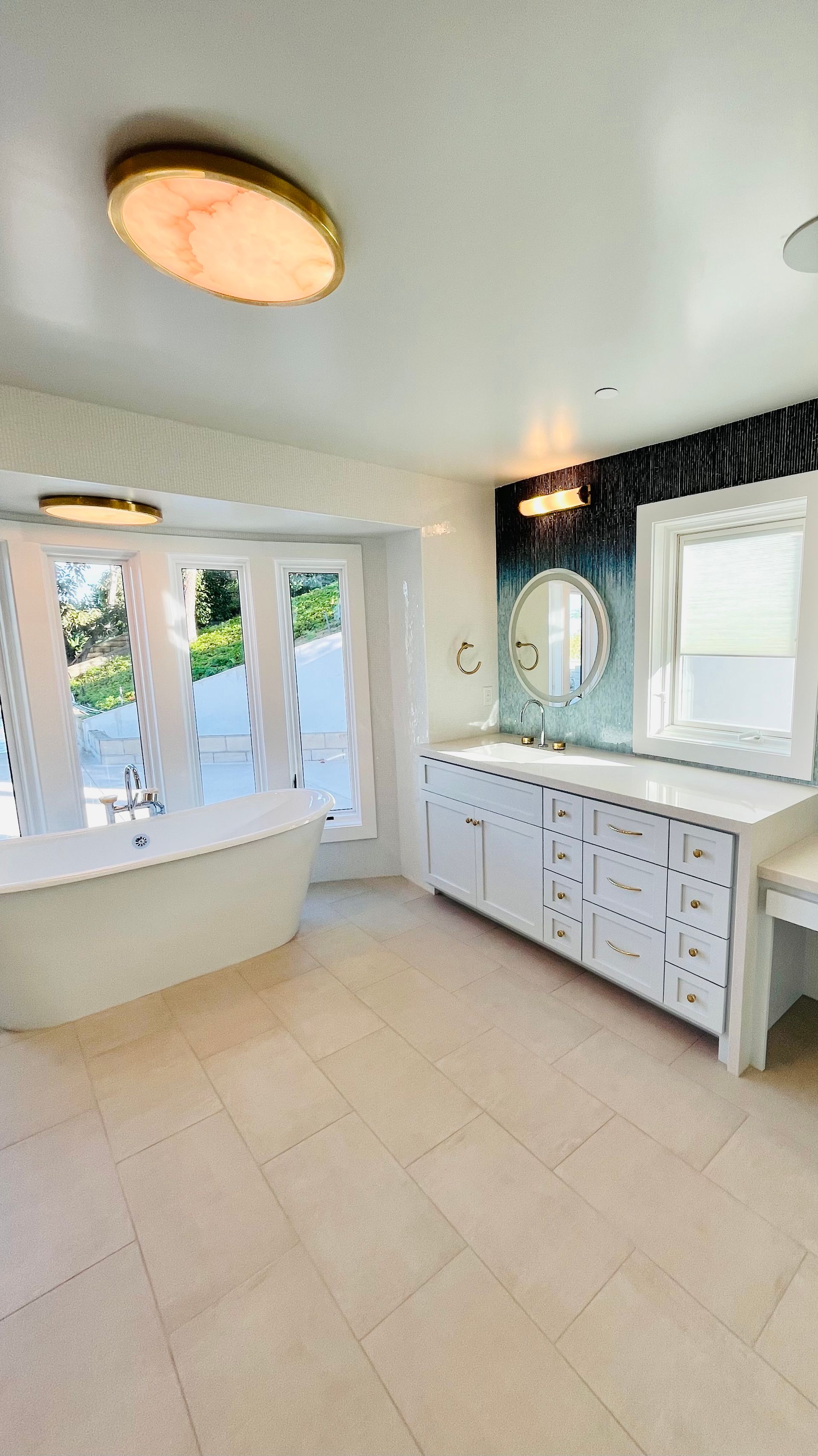 A bathroom with a tub , sink and mirror.