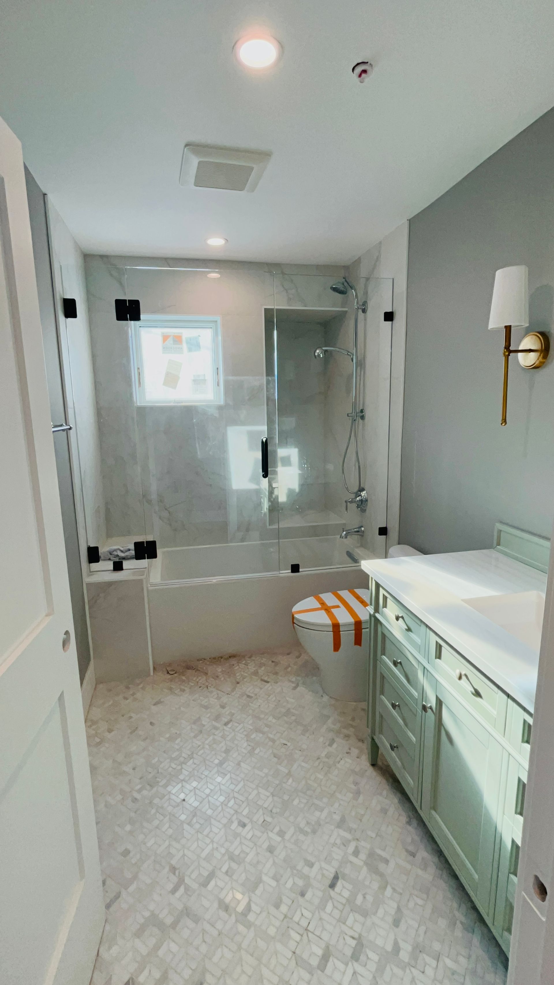 A bathroom with a sink , tub , shower and window.