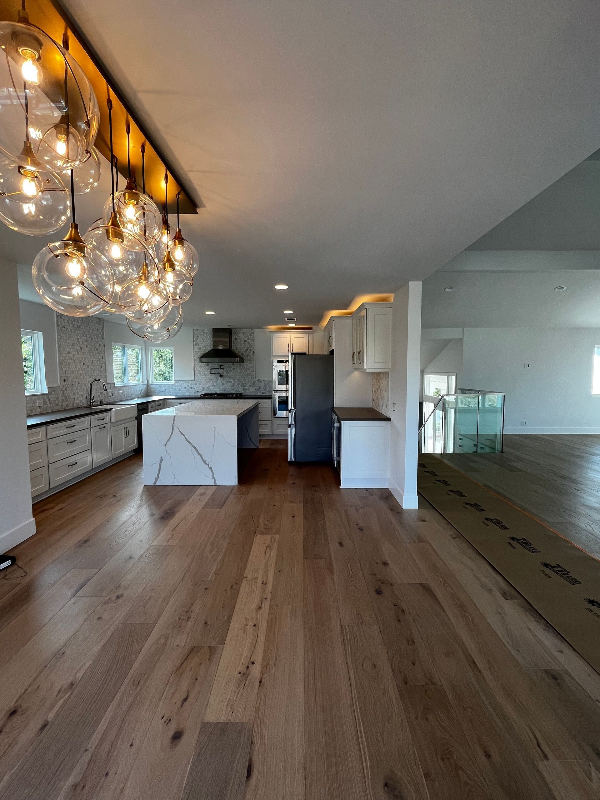 A kitchen with hardwood floors and a large island