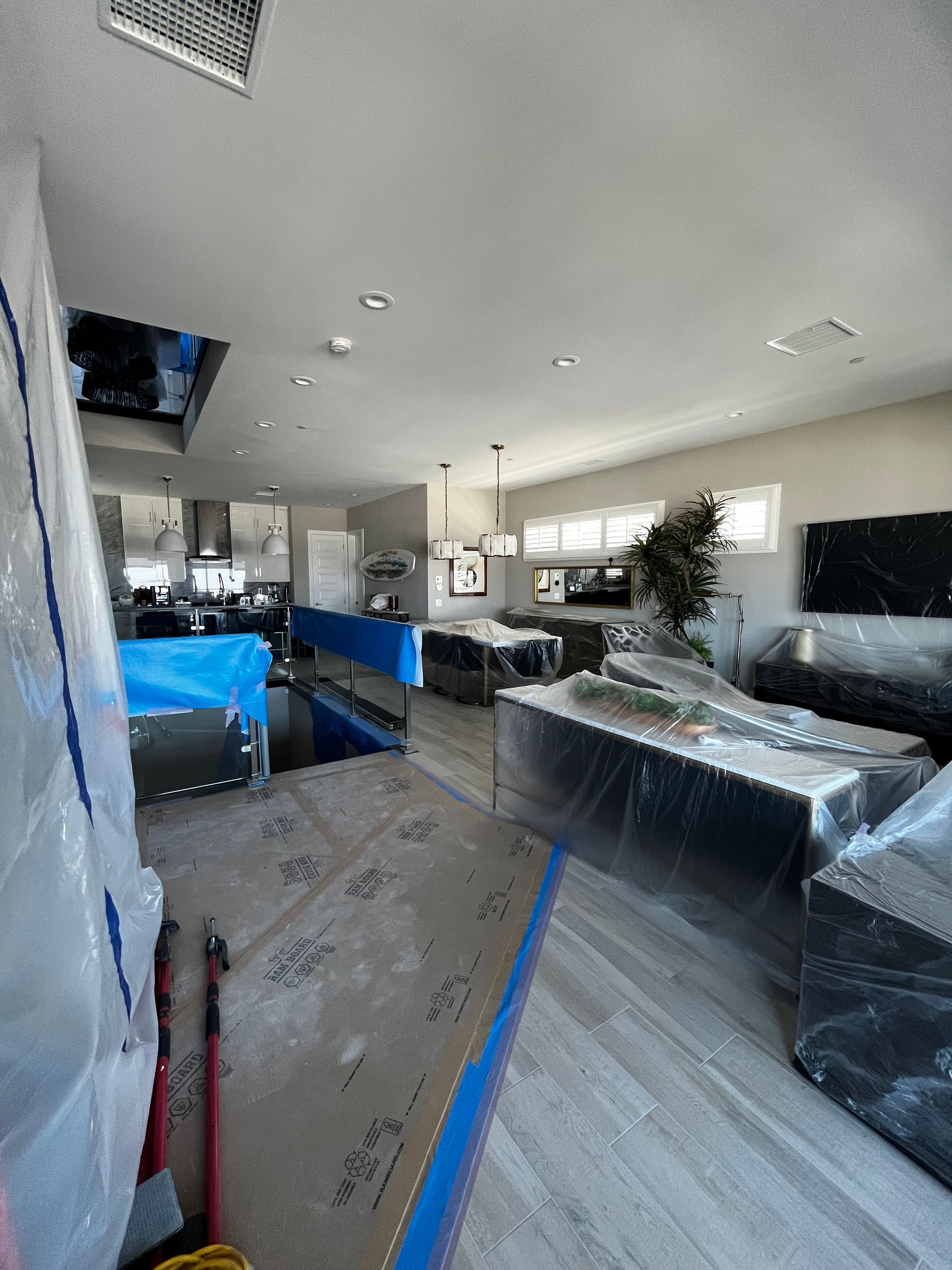 A living room is being remodeled and covered in plastic.