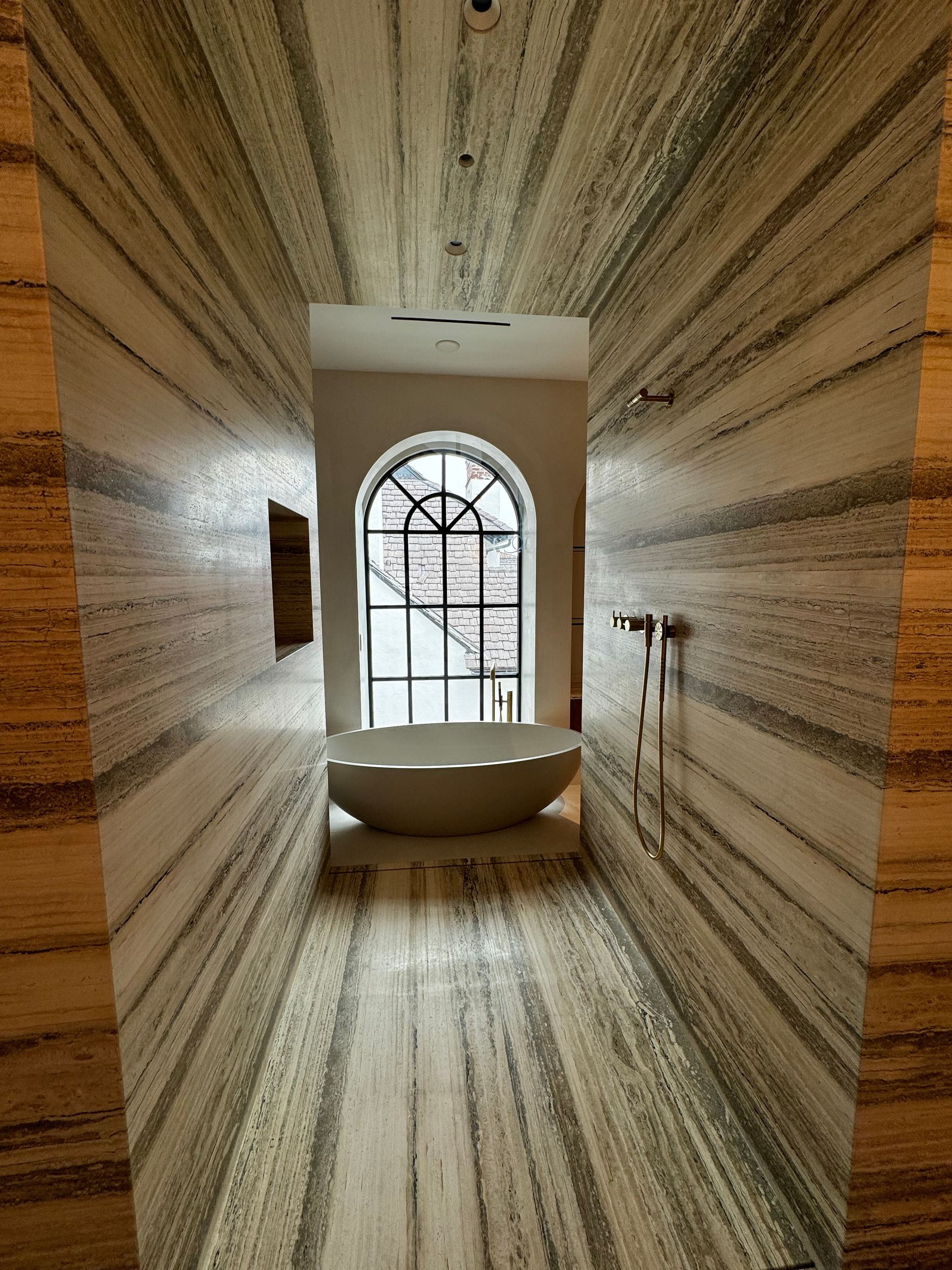 A bathroom with a large tub and a window.