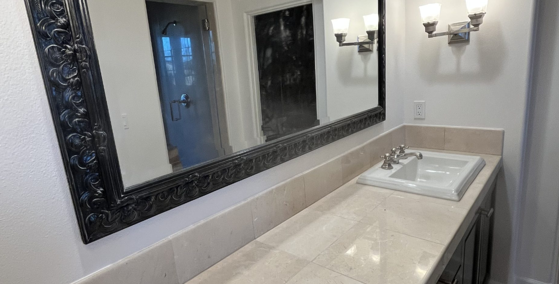 A bathroom with two sinks and a large mirror.