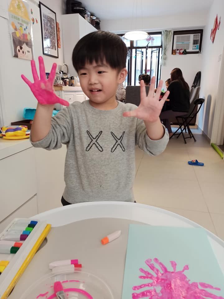 A young boy wearing a sweater with the letter x on it