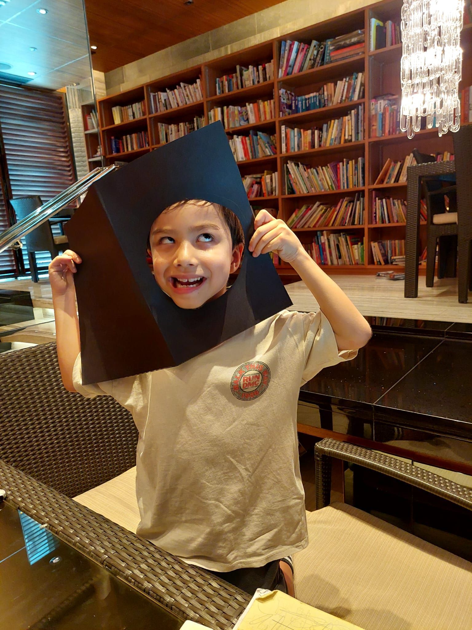 A young boy is wearing a graduation cap on his head.